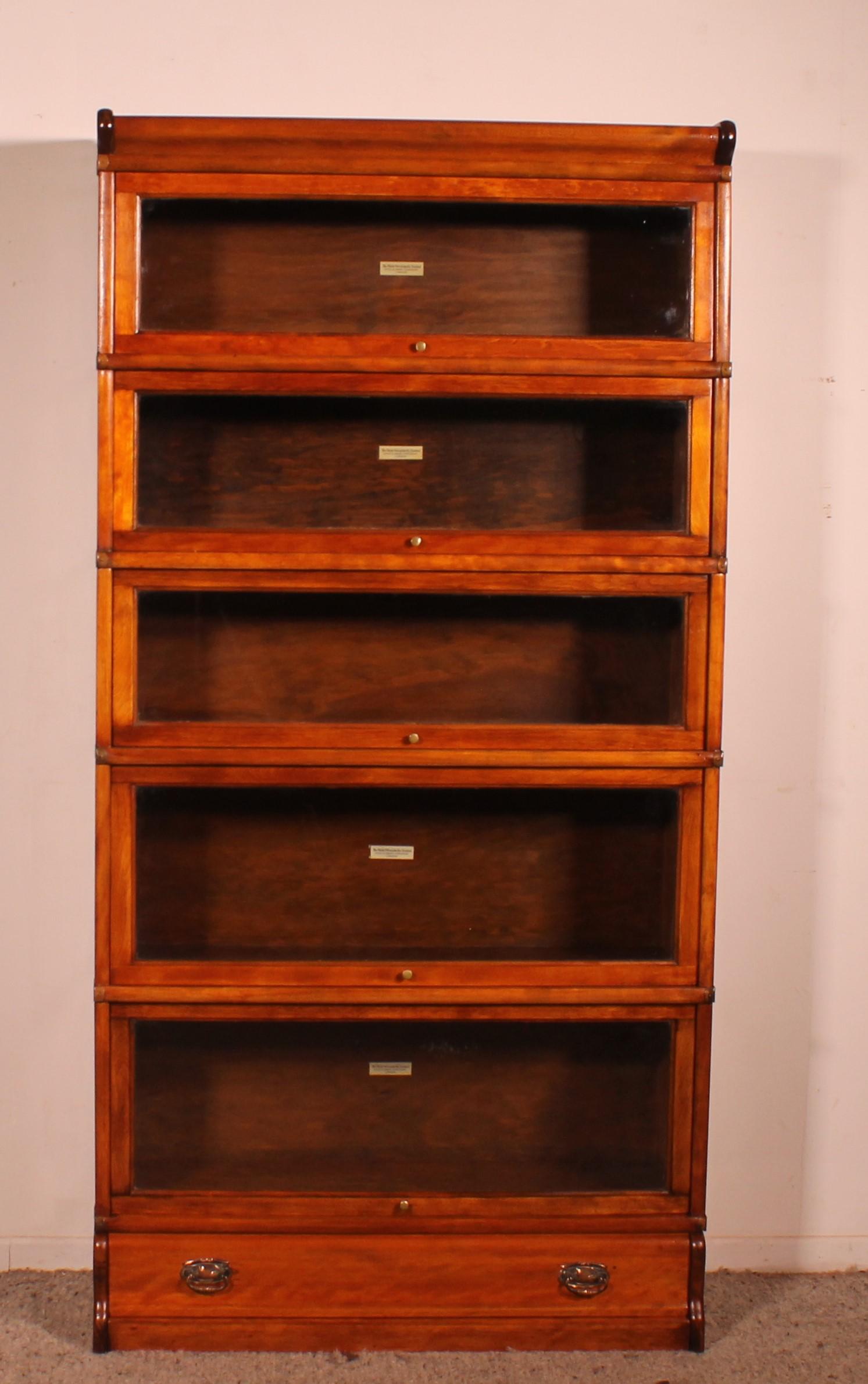 Elegant Globe Wernicke London bookcase in fruit wood from the end of the 19th century-early 20th century from England which has 5 elements and a drawer at the bottom. 

The bookcase is made of fruit wood which is rare. Our first in three