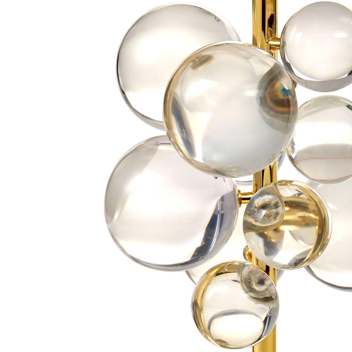 Lustrous sculpture. A constellation of clear Lucite spheres floats on a slim brass stem anchored by a sculptural marble base and topped with a brass dome. The shade refracts the light, makes the orbs sparkle, and creates a warm glow. The sculptural