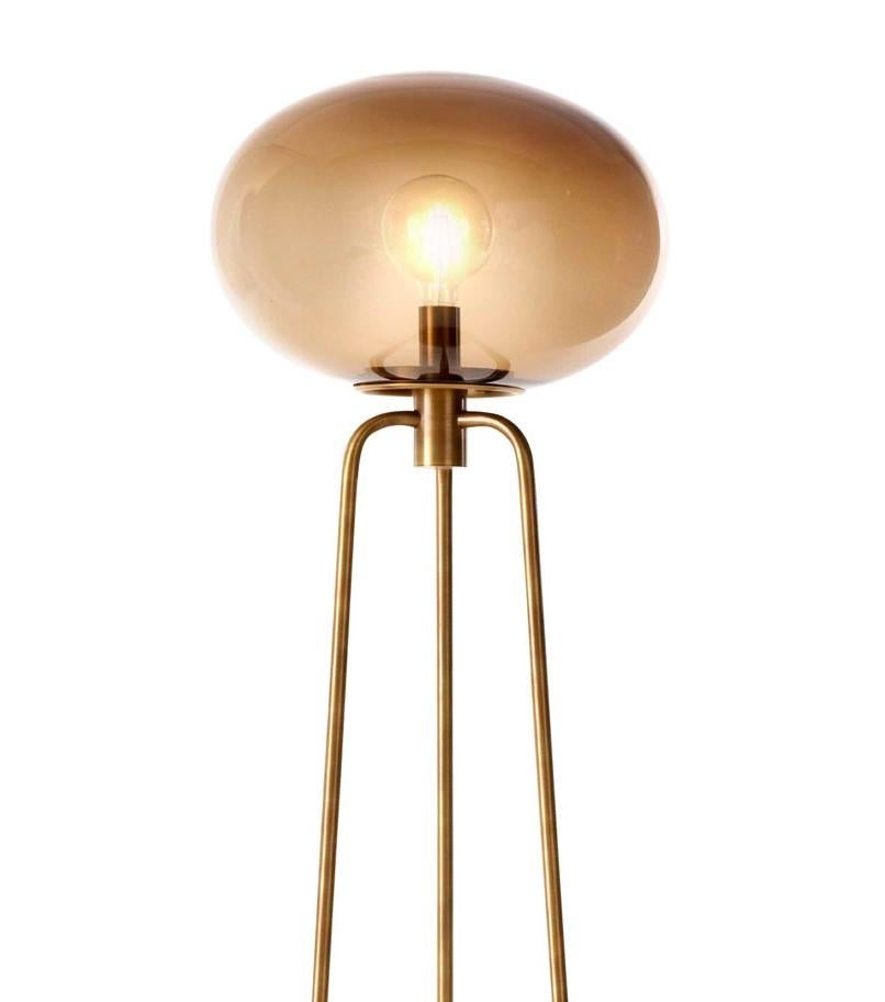 From of the Globo collection, this floor lamp buds timeless sophistication and will enrich both classic and contemporary decors. The modern silhouette comprises a round base from which stem the metal rods with a satin brass finish that bend at the