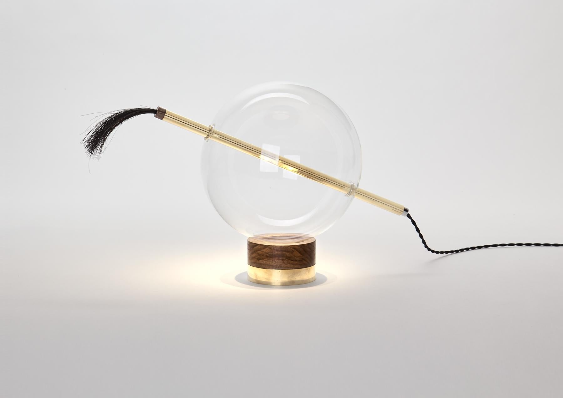 Designed to be positioned on a console table or to suggestively light up a corner on the floor, the Globo Neptune enjoys a particularly simple, flexible relationship with its Domestic Environment.
The light gets out from the brass rod crossing over