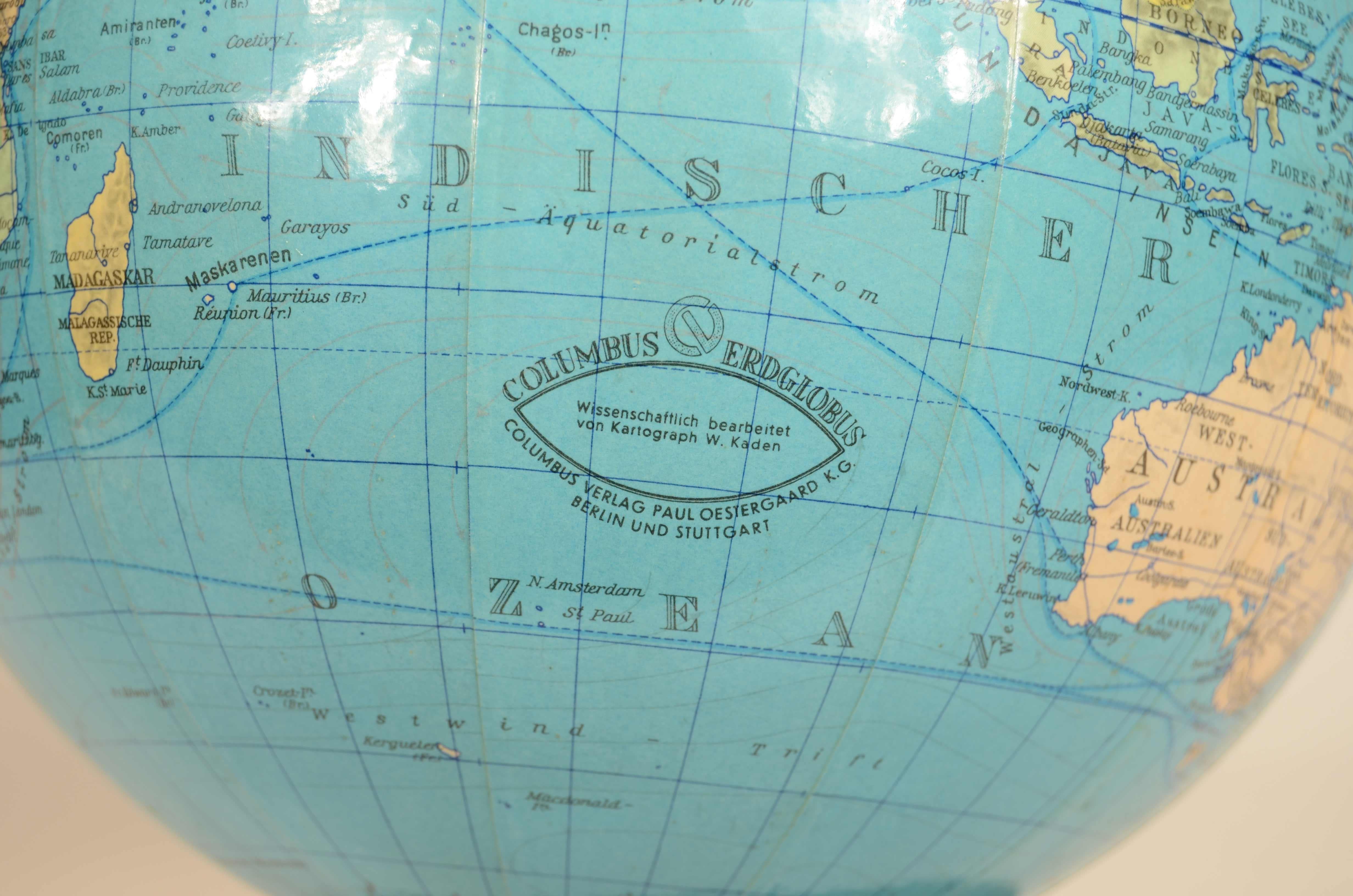 German terrestrial globe Columbus Erdglobus edited by German cartographer Paul Oestergaard in the 1950s. Papier maché ball with  wood and metal base complete with meridian circle. 
Good condition, excellent readability.
Height 27 cm - 10.6 inch,