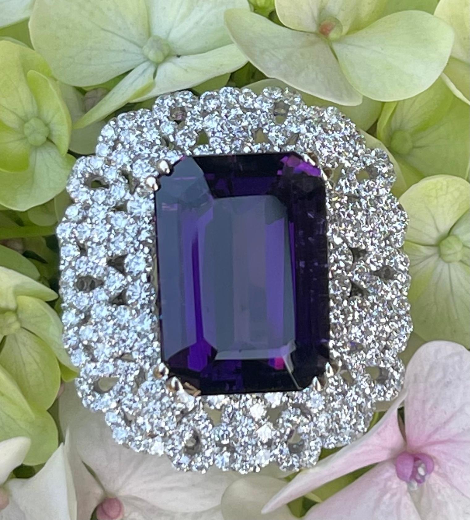 Magnificent 15.29 carat rectangular step-cut or emerald cut, deep purple Siberian amethyst is talon prong set above a dazzling approximately 7.38 carat diamond mounting featuring a repetitive flower and pear pattern of round brilliant white diamonds