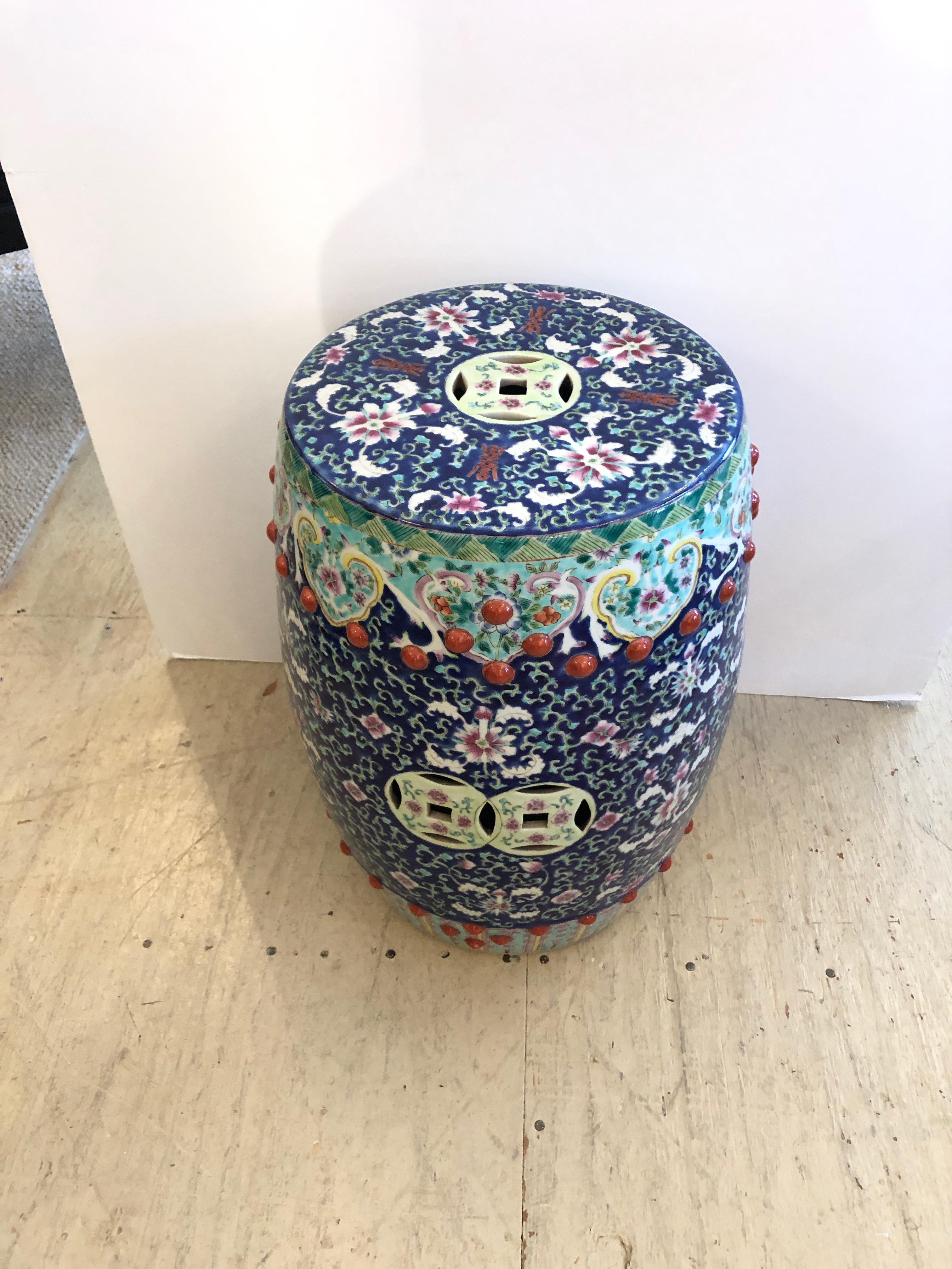 A magnificent intricately detailed ceramic garden seat having a melange of colors including navy blue, white, turquoise, pink and Chinese red. Makes a wonderful side or occasional table.