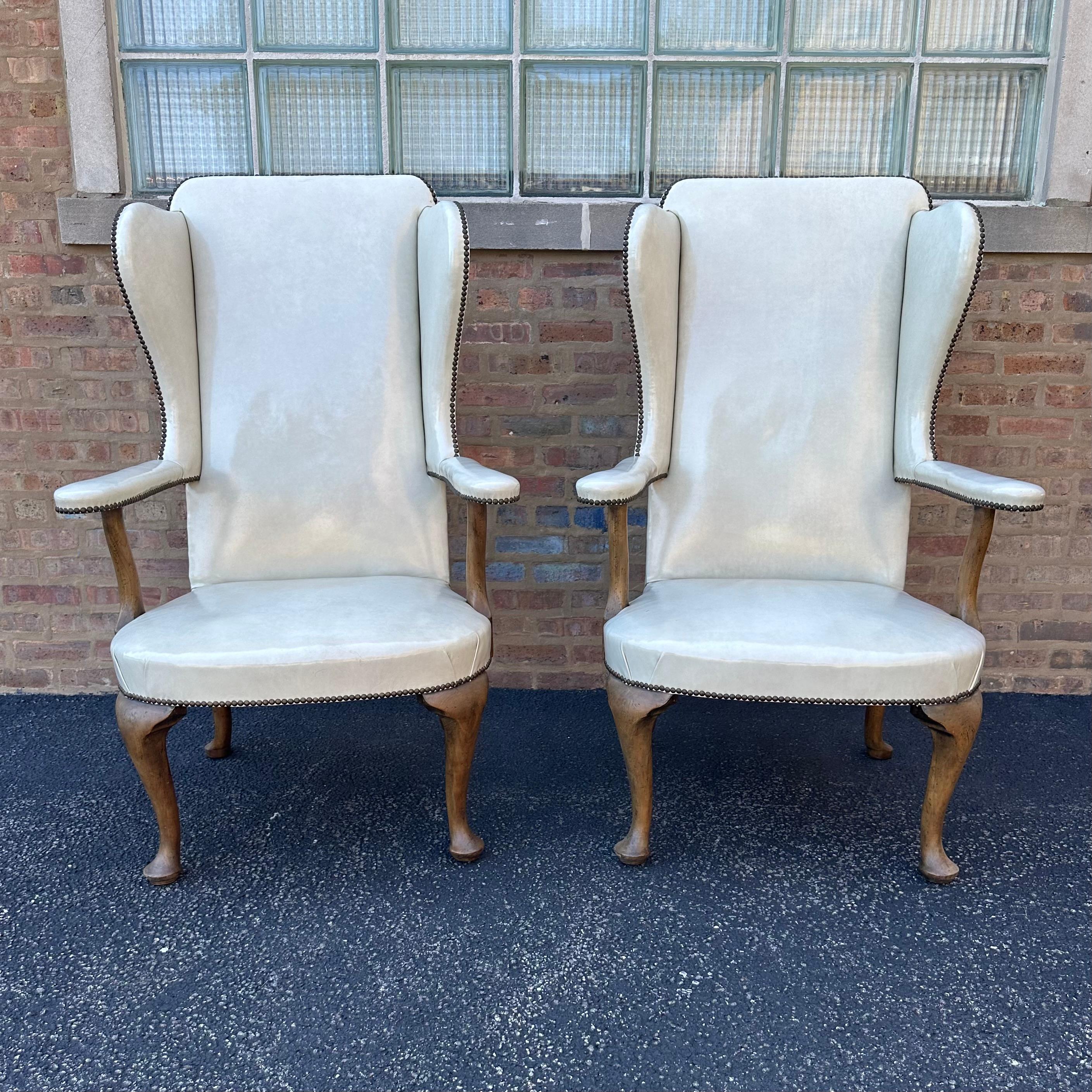 This fabulous pair of tall wingback chairs in the French Provincial style was designed by well-known interior designer, Richard Himmel, of Chicago, and produced in 1970. The high-back chairs are upholstered in the original glossy cream leather and