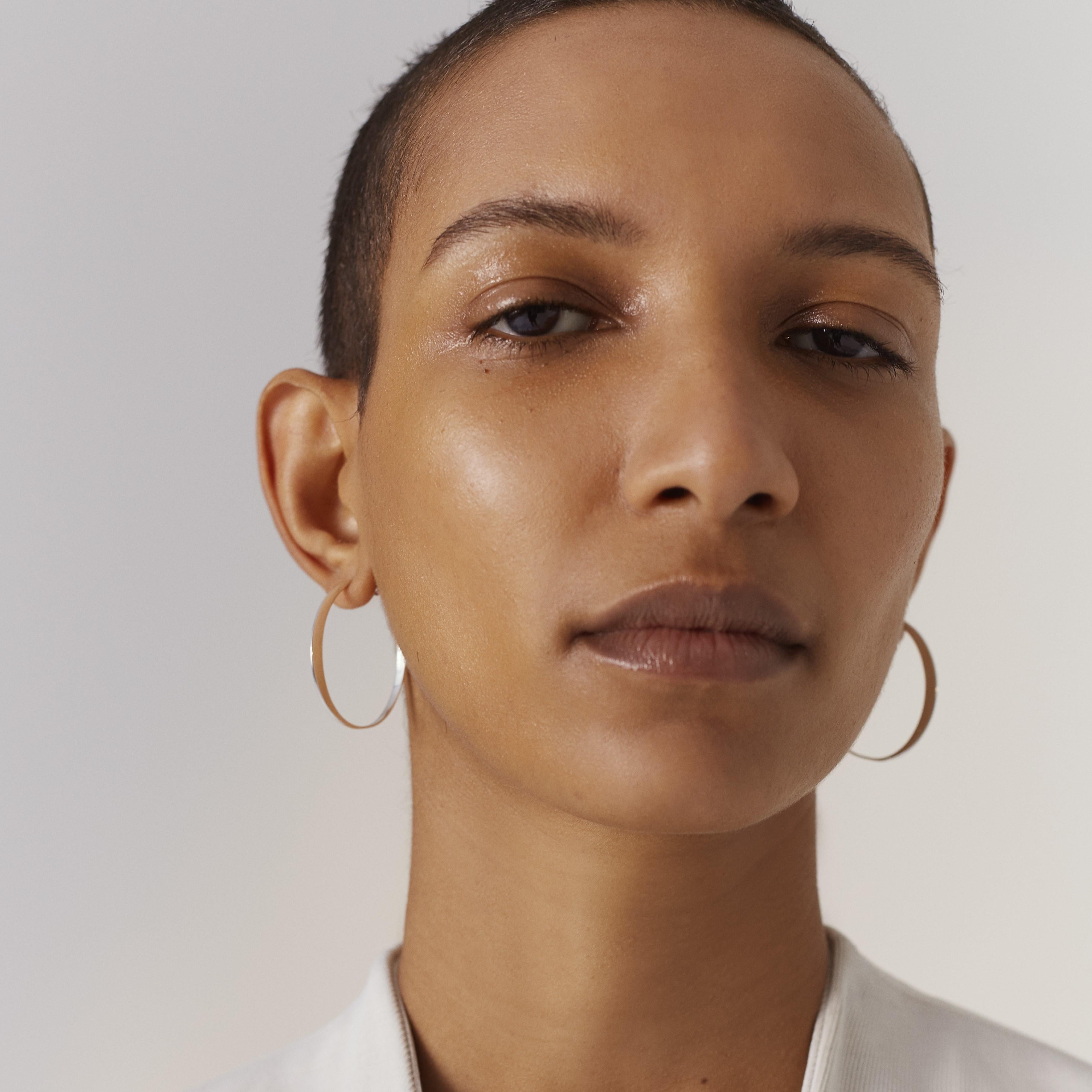 Also available in recycled 18k gold; as a pair, or in size small and large.

Introducing the medium GLOW hoop earring, a stunning piece of Danish design crafted in Copenhagen. This architectural earring is handcrafted using recycled sterling silver,