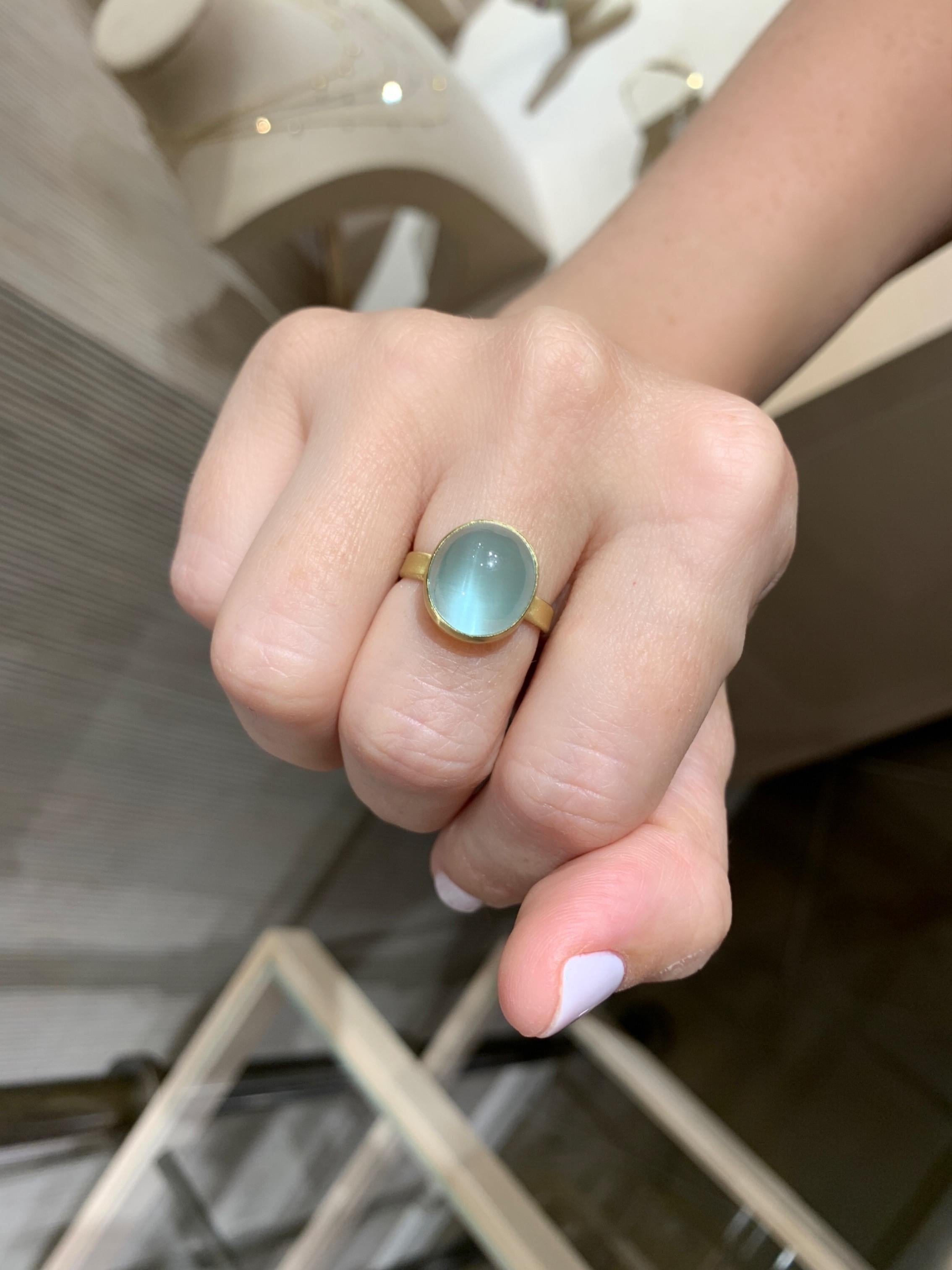 One of a kind ring hand-fabricated by acclaimed jewelry artist Monica Marcella in the maker's signature-finished 18k yellow gold showcasing a magical sky blue natural aquamarine cabochon with cat's-eye optical effect. Size 7 (can be sized upon