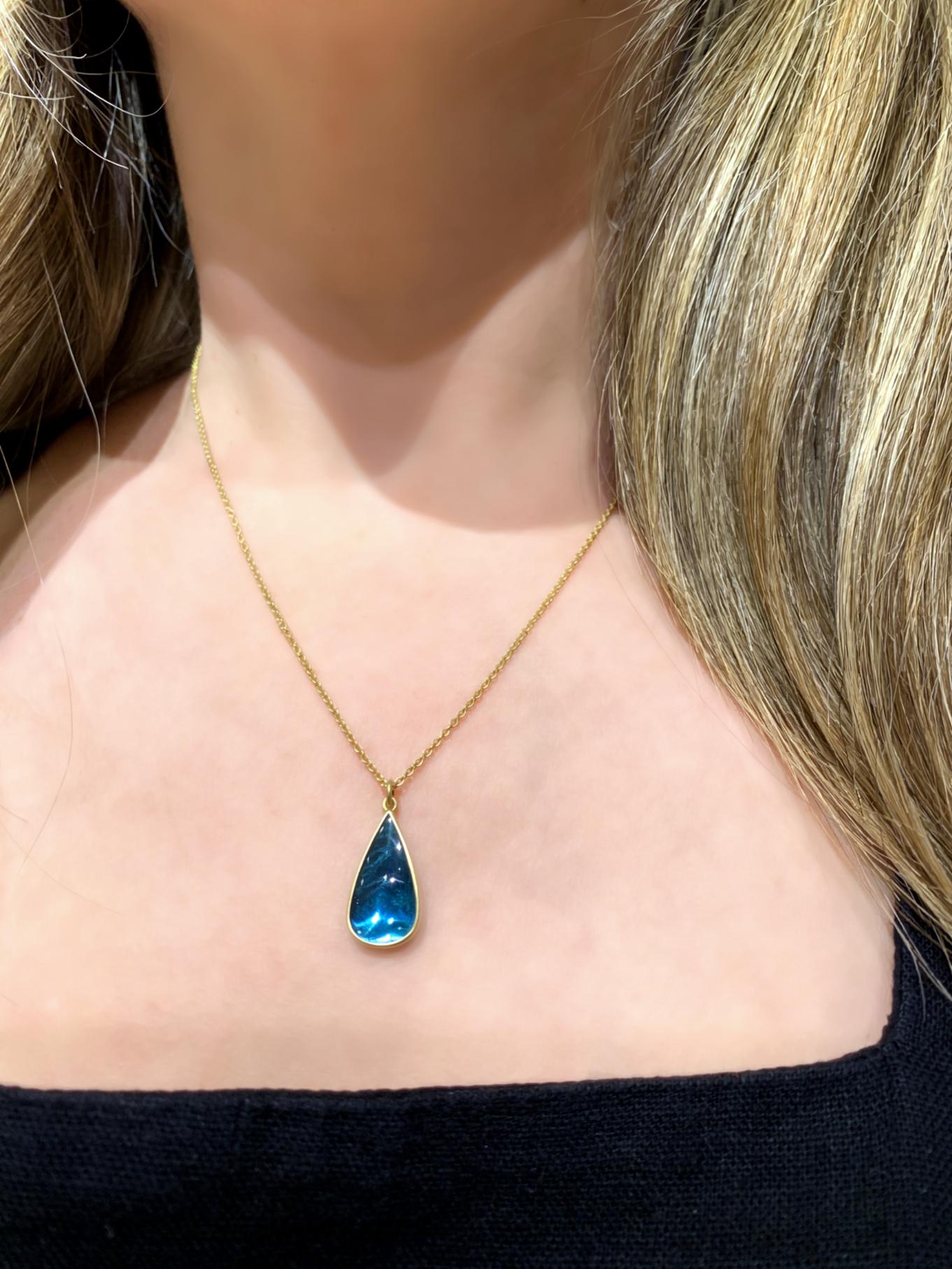 One of a kind necklace hand-fabricated by acclaimed jewelry maker Lola Brooks in the artist's signature-finished 18k yellow gold showcasing a glowing deep blue indicolite tourmaline cabochon pear totaling 3.82 carats on an 18k yellow gold chain. 
