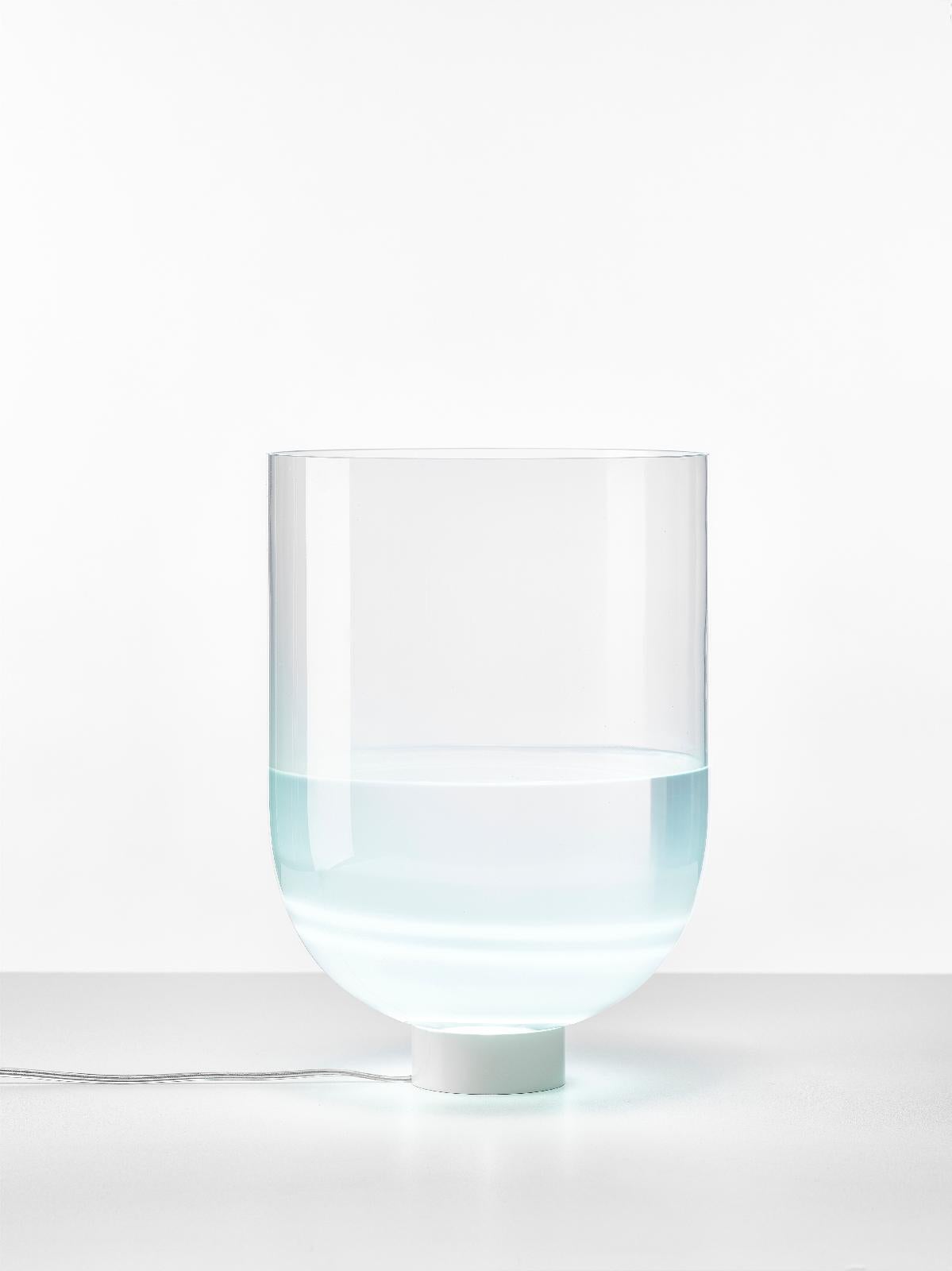Glowing vase table lamp by Dechem Studio.
Dimensions: D 25.5 x H 38.5 cm.
Materials: glass.
Available in 2 sizes: H23.5, H38.5 cm.

Something between vase and lamp, Glowing Vase is a hybrid interior object, produced in clear cloudy glass with a