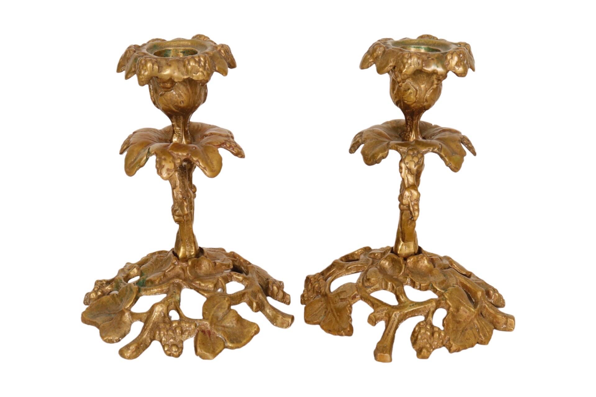 A pair of brass Glo-Mar Artworks of NY candlesticks in the form of twisting grape vines. The capital, stem and base are separate pieces cast in an intricate pierced design with vine leaves and grape bunches throughout. The candlesticks are stamped