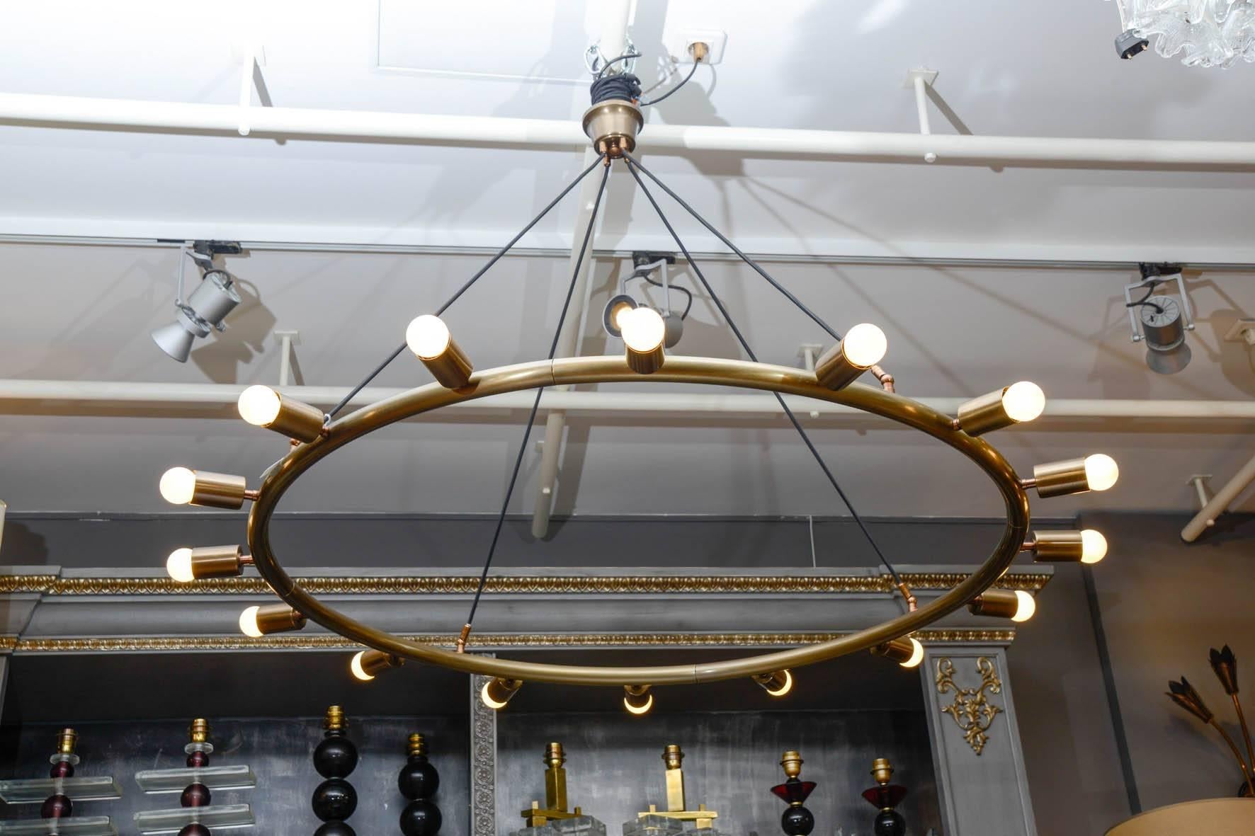 Glustin Luminaires design, brass hoop chandeliers suspended by fabric wires which height can be adjusted.