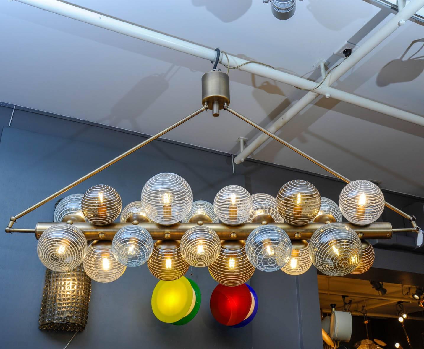 New chandelier by Glustin Luminaires, bronze finish brass central rod with twenty Murano glass globes with color swirls in them.