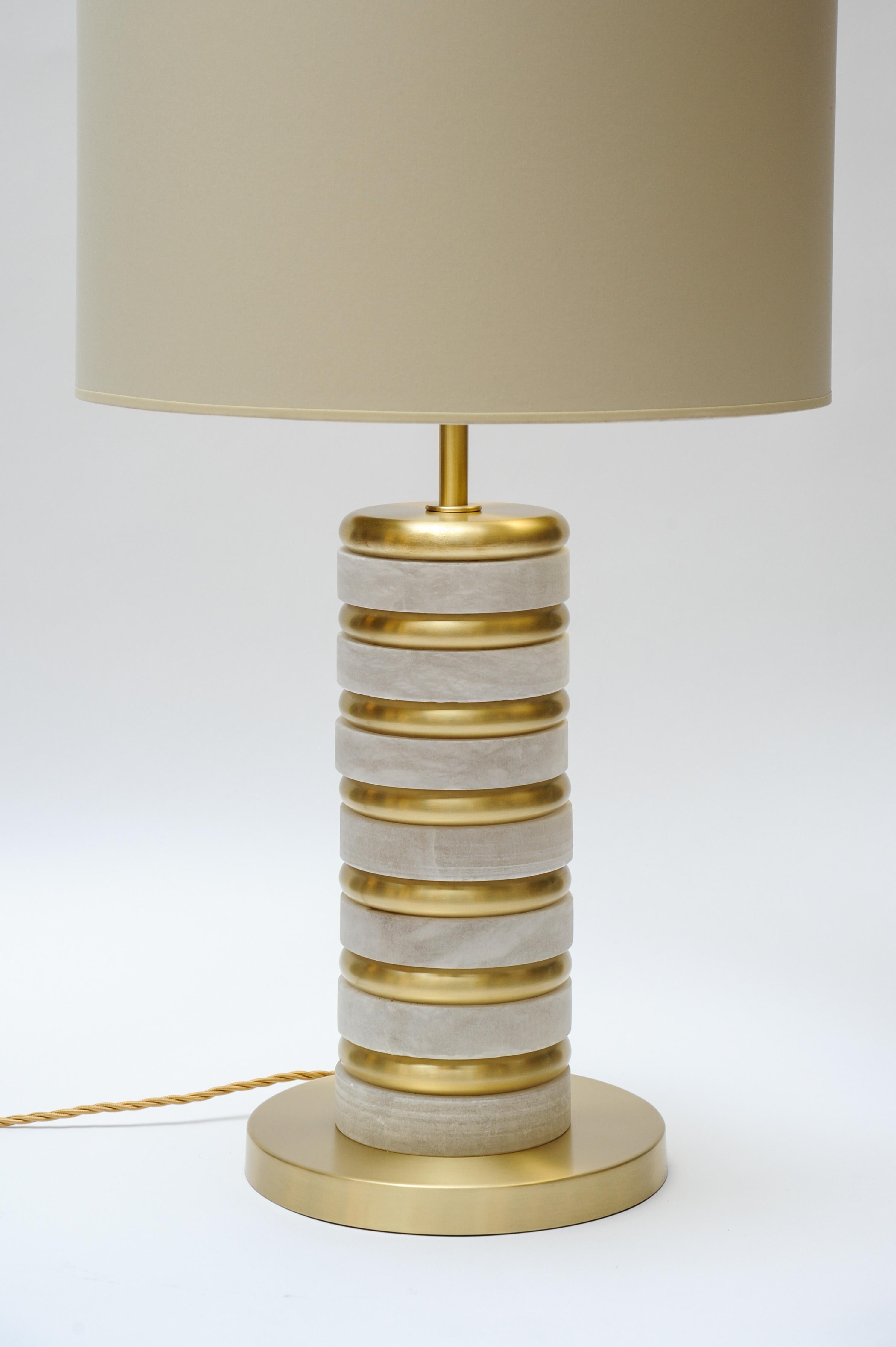 Pair of table lamps made of stacked thick alabaster and brass rings.