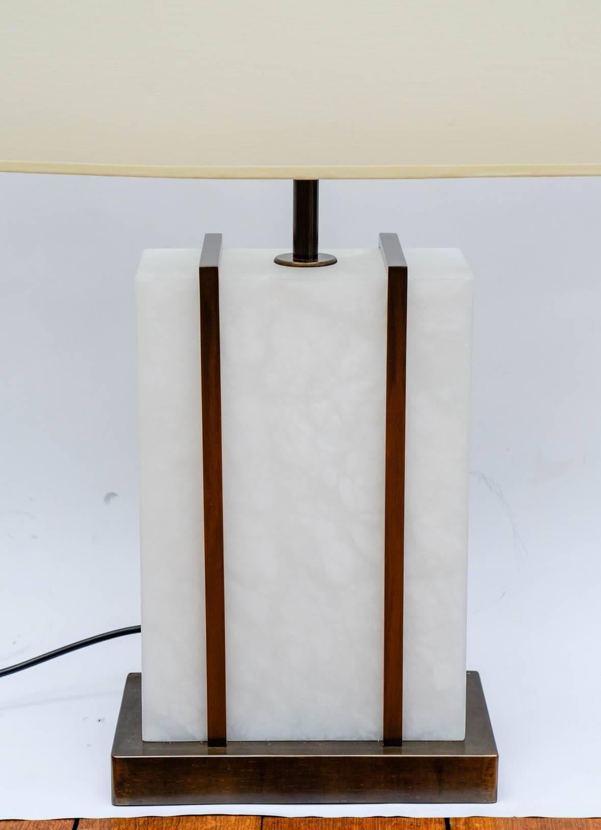 Pair of rectangle table lamps, made of brass feet with soft edges, a large alabaster centerpiece set by two brass frames. 

The lamps provide lights from above and inside the alabaster, both can be controlled separately.
 