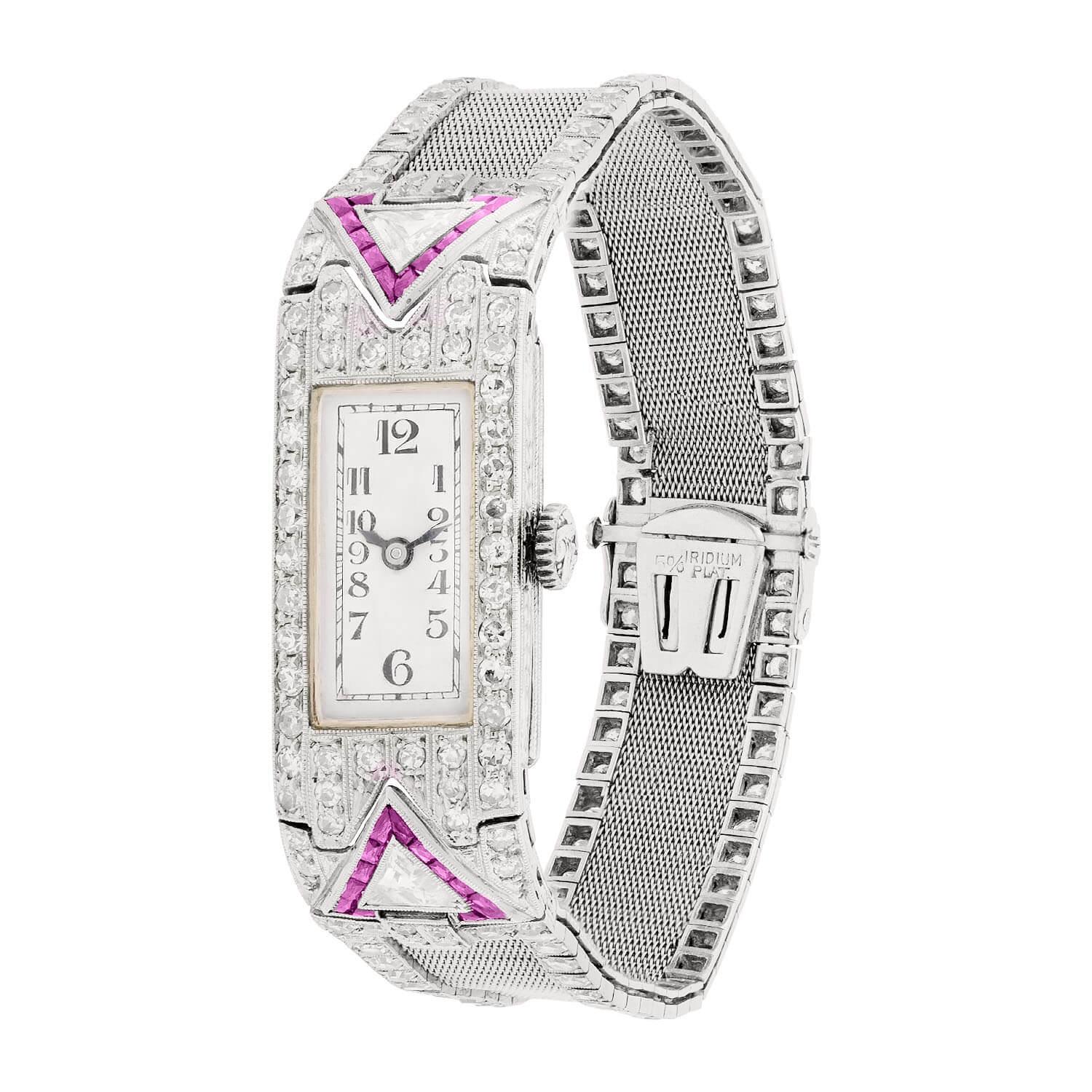 A fabulous platinum, diamond, and ruby Glycine watch from the Art Deco (ca1920s) era! This gorgeous watch has a rectangle-shaped watch face, which is surrounded by a wonderful and feminine design that is encrusted with sparkling diamonds and