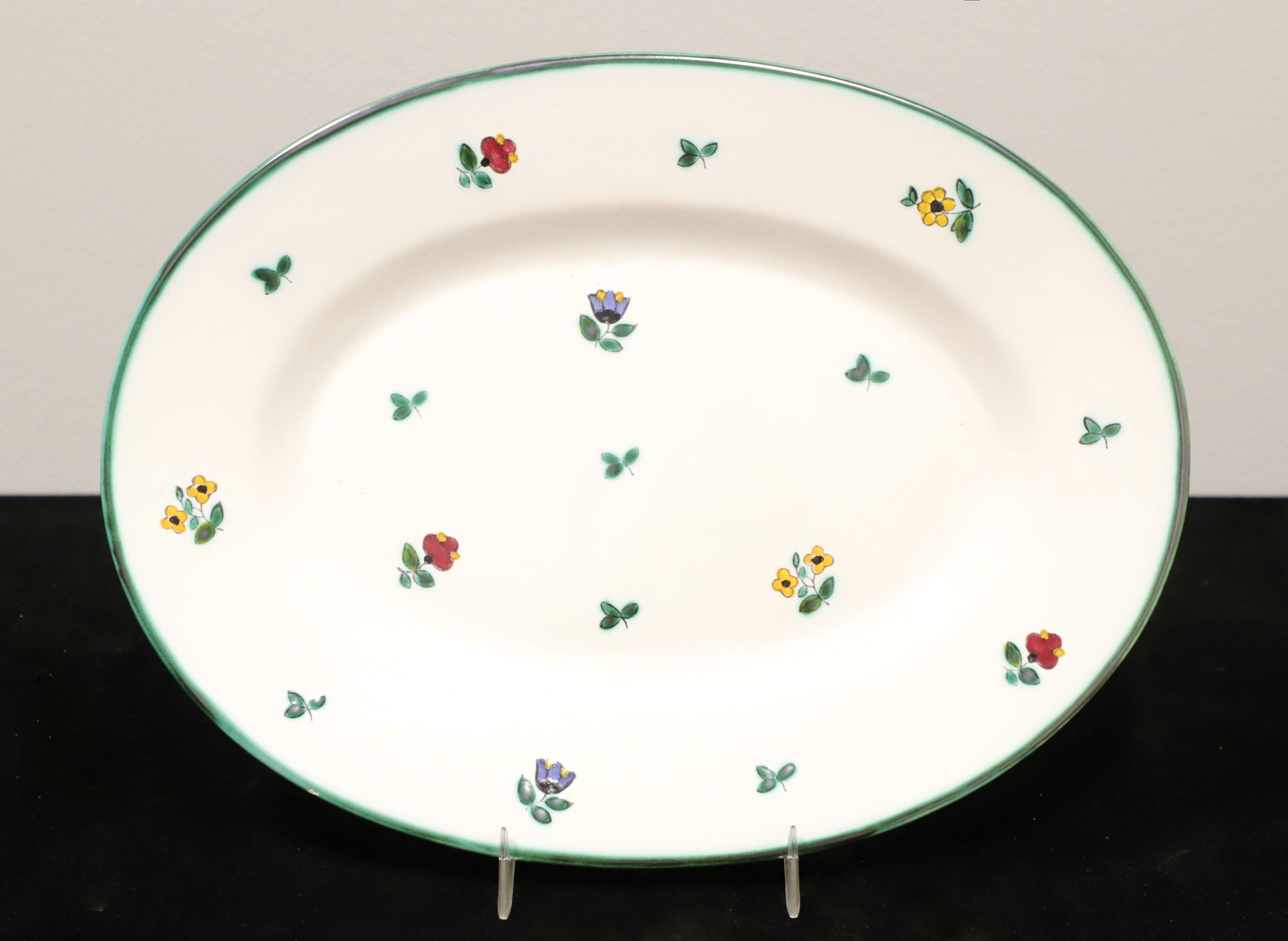 A set of four Mid 20th Century serving pieces by Gmundner Keramik, in their Streublumen (Scattered Flowers) pattern. All are hand made ceramic and hand painted depicting scattered various color flowers & green leaves with a solid green border. Set