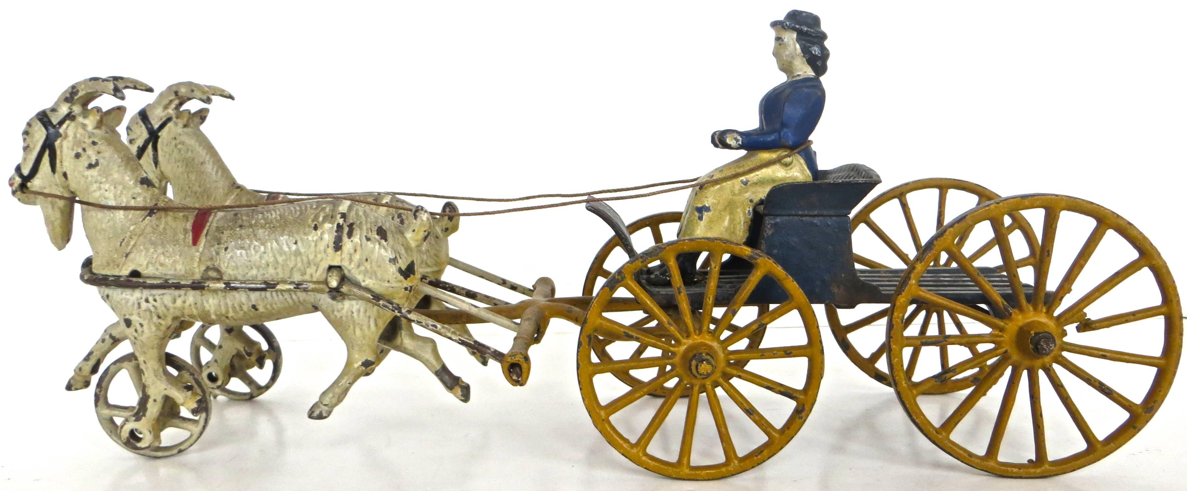 Cast iron turn of the century American toy, this rare and hard to find version with a double goat drawn buckboard and lady driver, was manufactured by the Harris Toy Company, Toledo, Ohio, circa 1903. It appears in a catalogue on that date but could