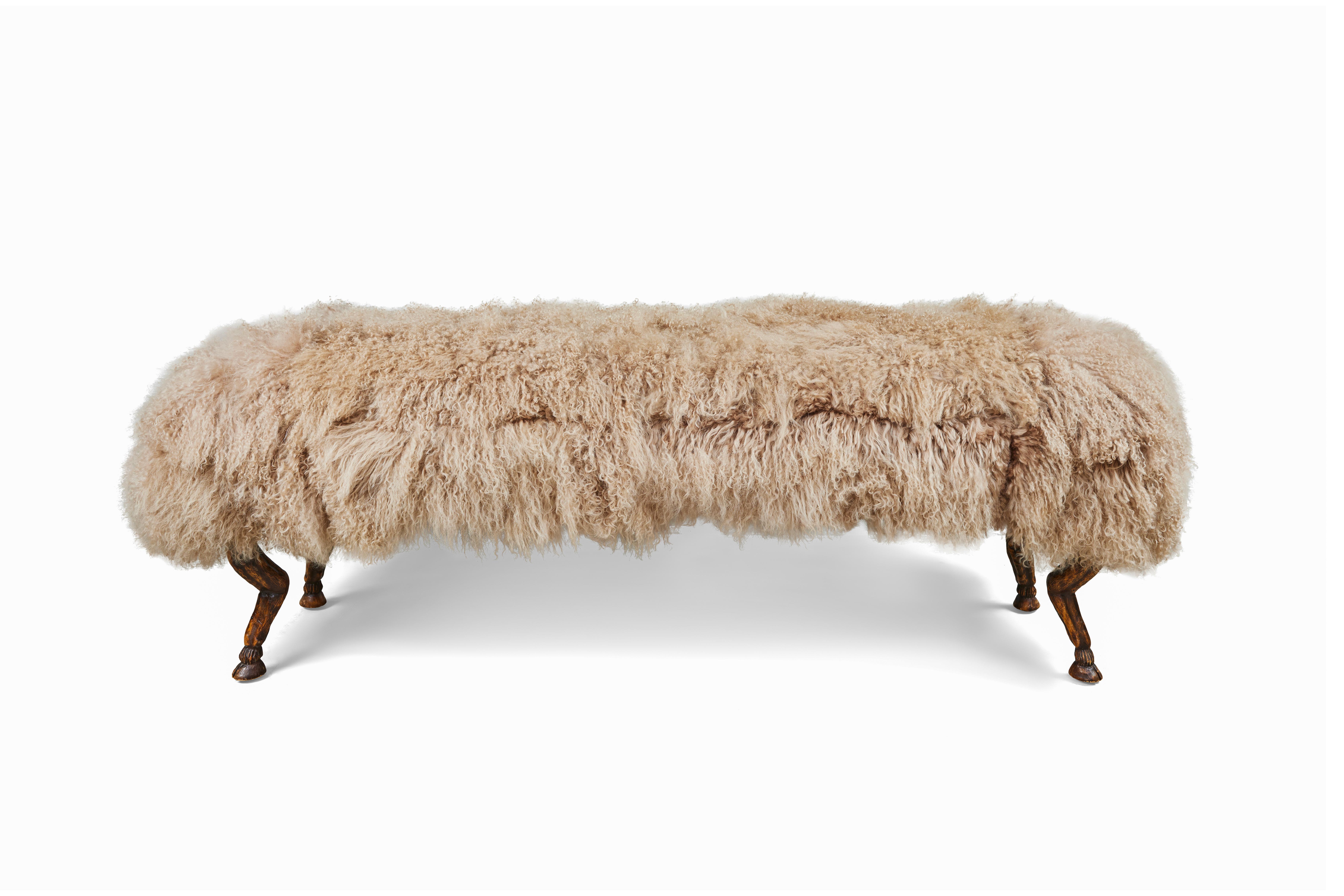 Glamorous vintage bench with goat foot legs in carved walnut and newly upholstered in a caramel color Mongolian curly lamb.