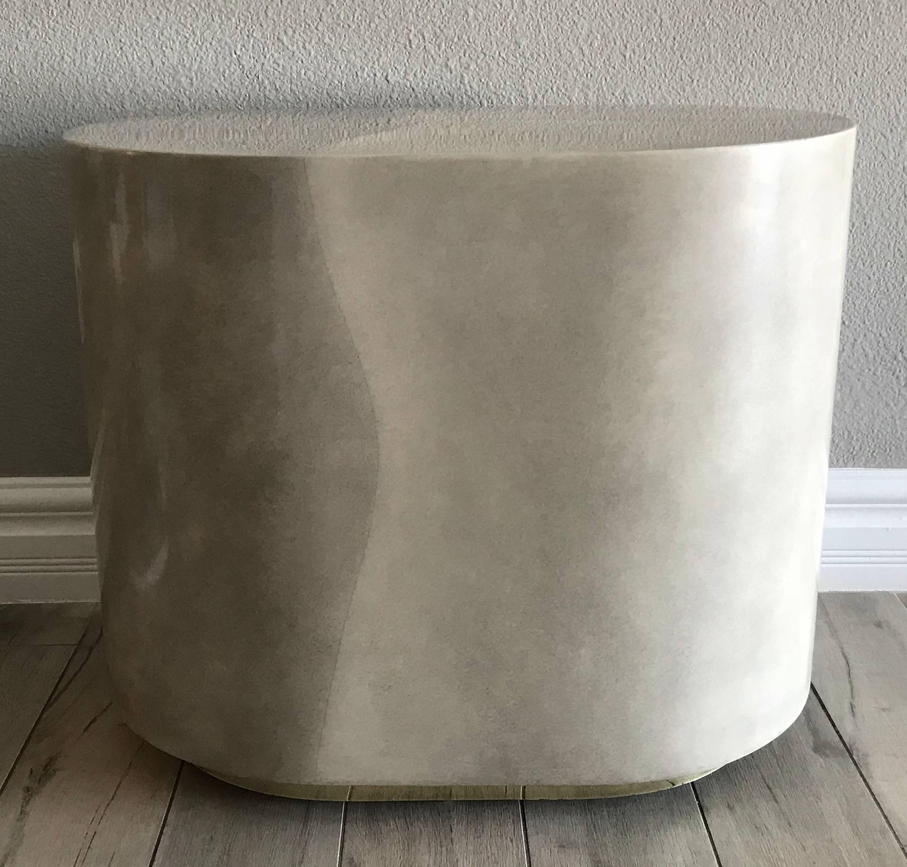 A stunning faux goatskin and brass plinth base cocktail or side table, in the style of Karl Springer.