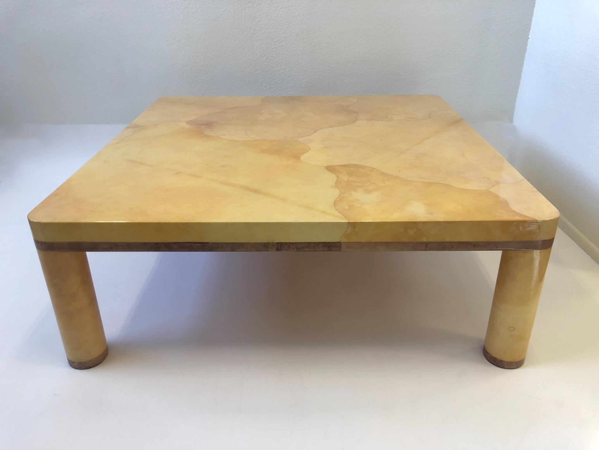 A spectacular 1980s goatskin coffee table designed in the style of Karl Springer. The table is constructed of wood that’s covered with natural goatskin and a light purple stained goatskin edges the table does have a minor repair on one of the