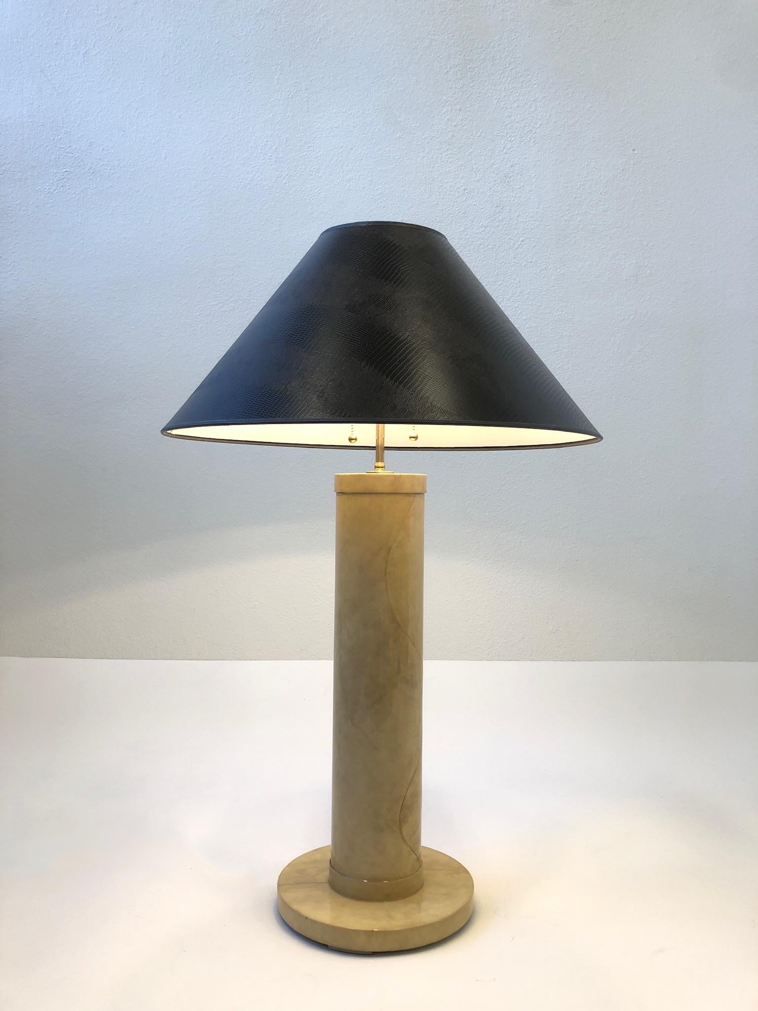 Beautiful 1980s goatskin parchment table lamp by J. Robert Scott.
Constructed of wood that’s covered with goatskin and then clear lacquered.
Newly rewired with new brass hardware and new brown faux reptile print shade. 
Measurements: 24” diameter
