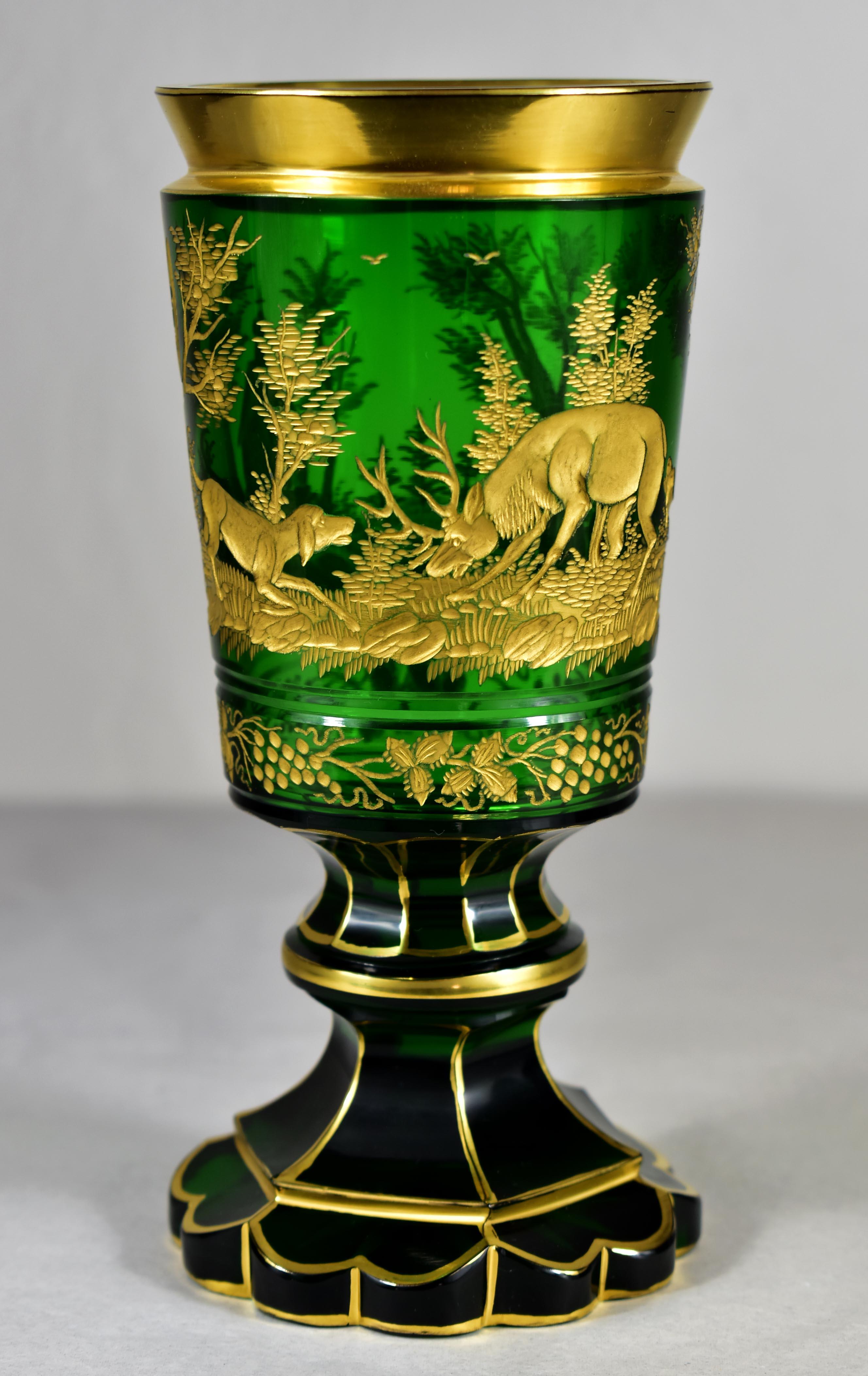 A beautiful glass goblet made of green glass, the goblet is cut, decorated with an engraving of a hunting motif. Motif depicting a deer defending itself from hunting dogs, Next, nature is depicted with the architecture of the chapel. the cut edges