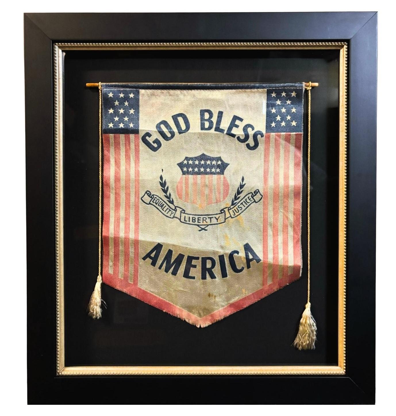 Presented is an original “God Bless America” banner, dating to World War I. The pointed gonfalon banner is patriotically printed in red and blue. “God Bless America” is printed along the top and bottom of the banner in large blue letters. A Union