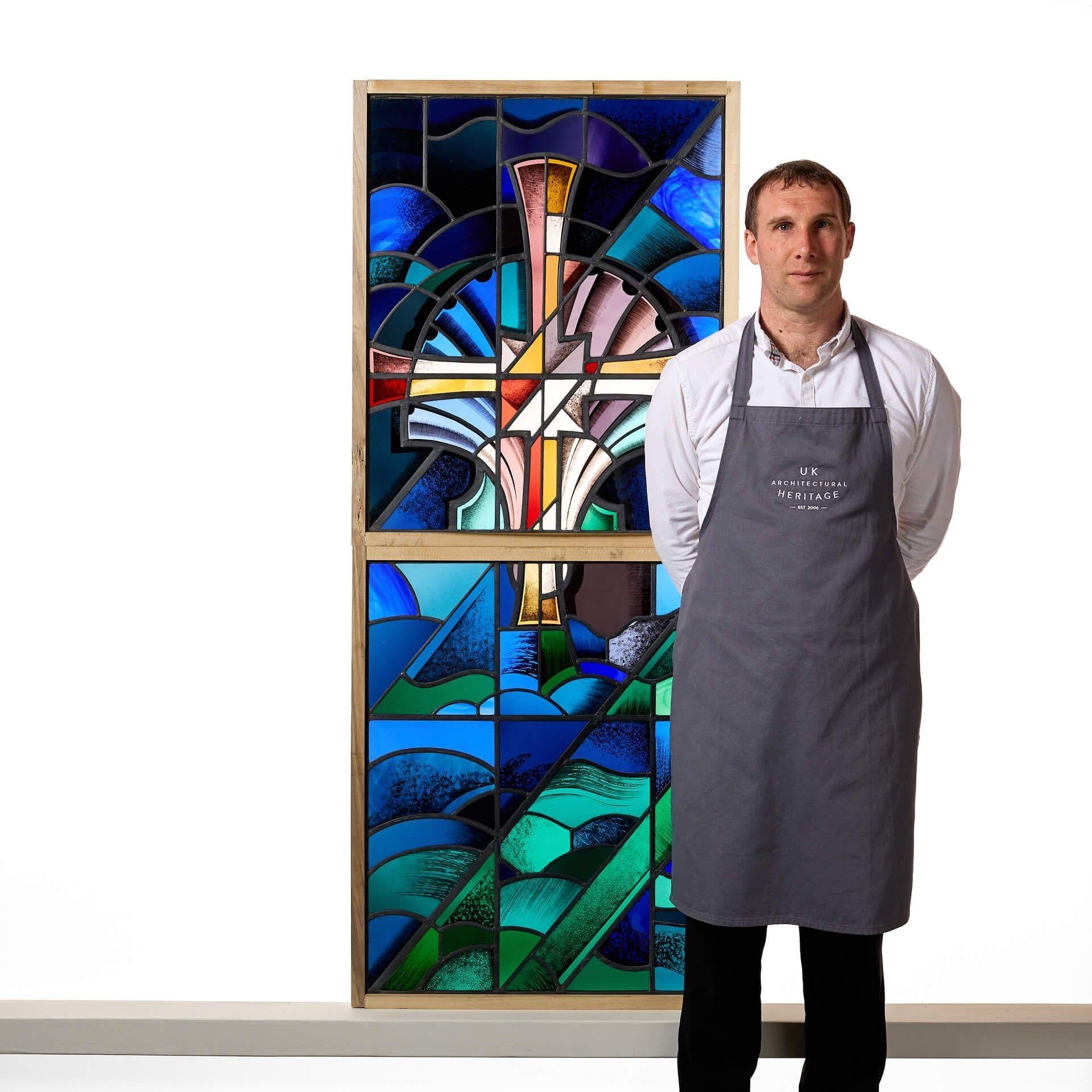An impressive Goddard & Gibbs geometric style stained glass window.
The vibrant colours and patterns are emphasised by the eye catching stylised geometric cross on this abstract modernist stained glass.
The perfect characterful window to be flooded