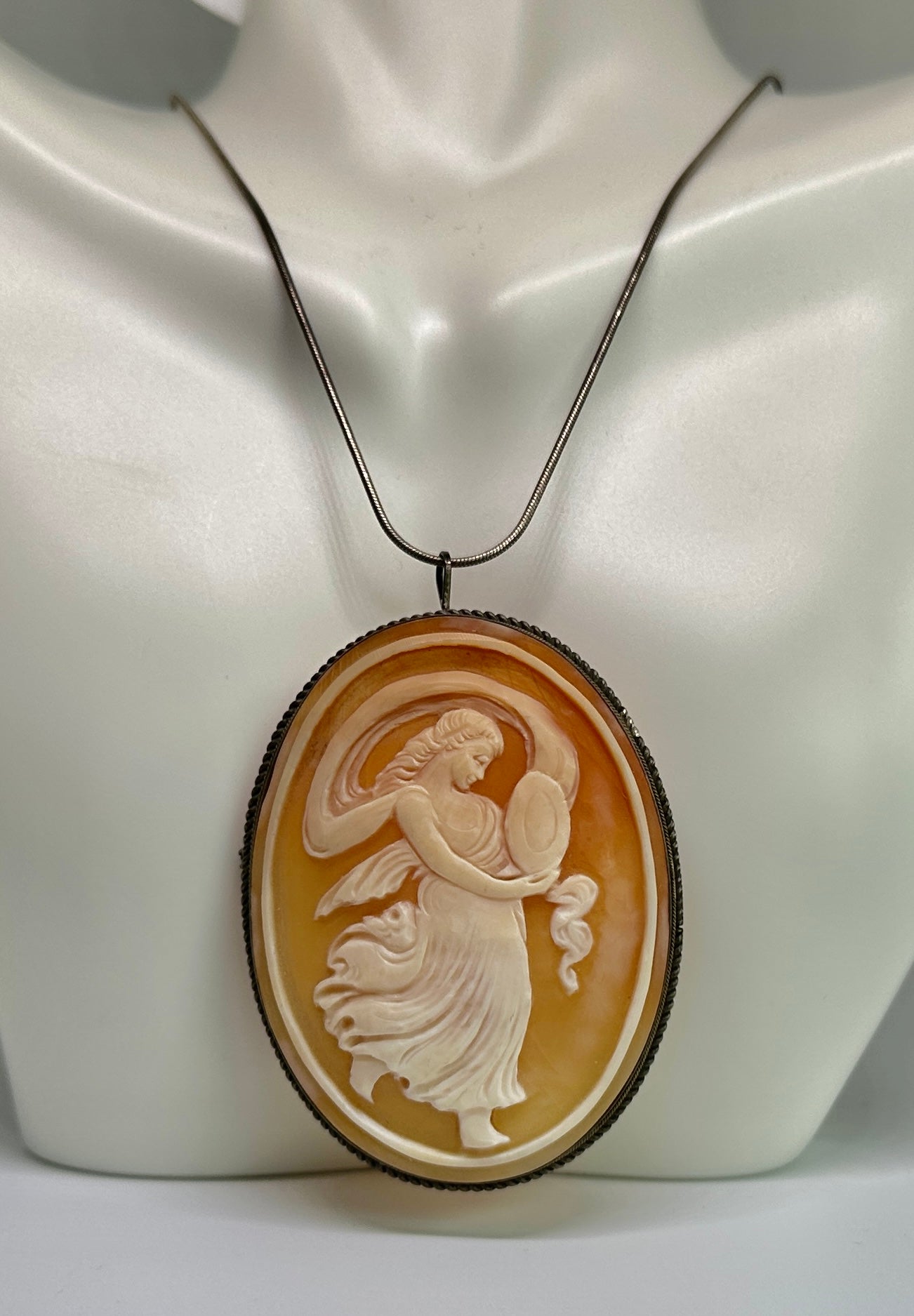 This is an absolutely stunning and very rare large antique Shell Cameo Pendant Brooch with a hand carved image of a Goddess Maiden with wonderful swirling robes and scarf. The cameo is set in silver and has a bale to be worn as a necklace as well as