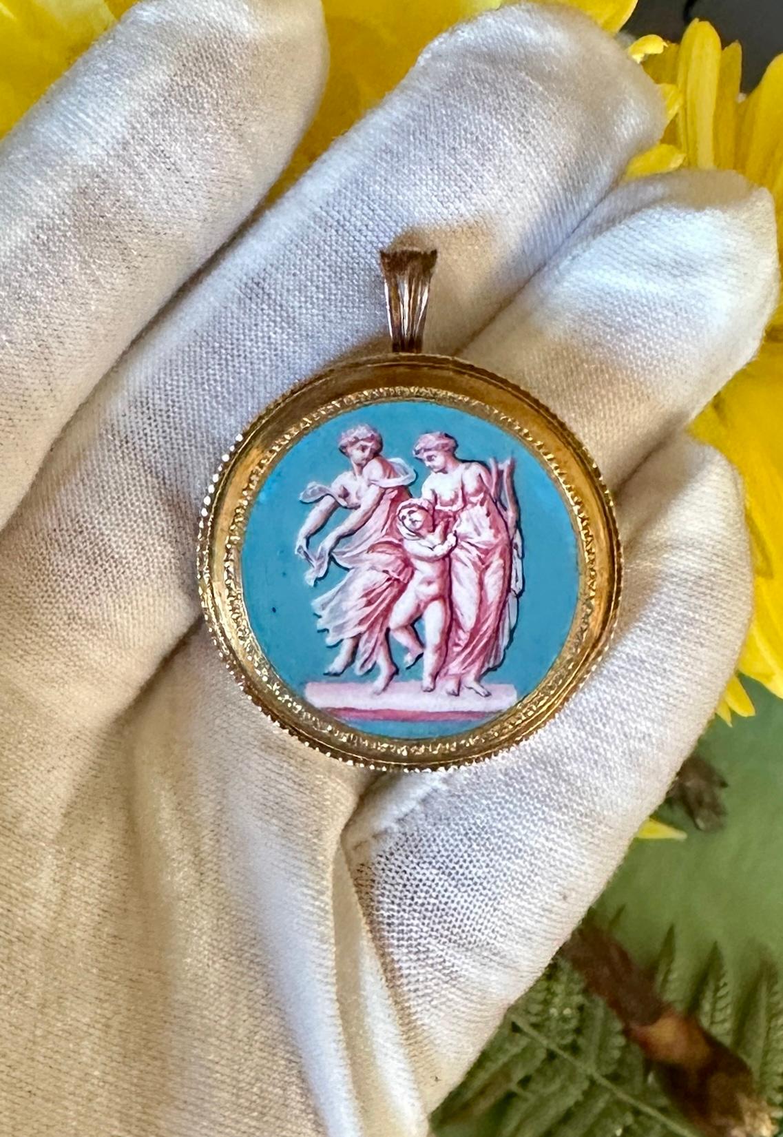 This is an extraordinary antique Enamel 18 Karat Gold Pendant or Brooch with a stunning hand painted image of two Goddess figures with a Cherub or Angel.  The neo-classical pendant is in the Etruscan Revival style with exquisite gold work and an
