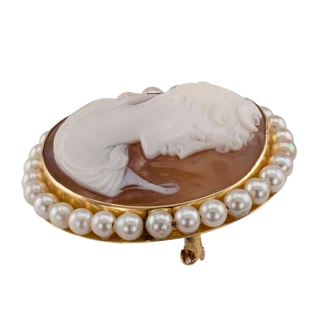 Goddess Diana 1930s shell cameo brooch pendant with pearls and gold. A departure from the more traditional oval-shaped cameo, this circular design features the profile of goddess Diana, a fine and detailed, crisp carving on Sardinian conch,