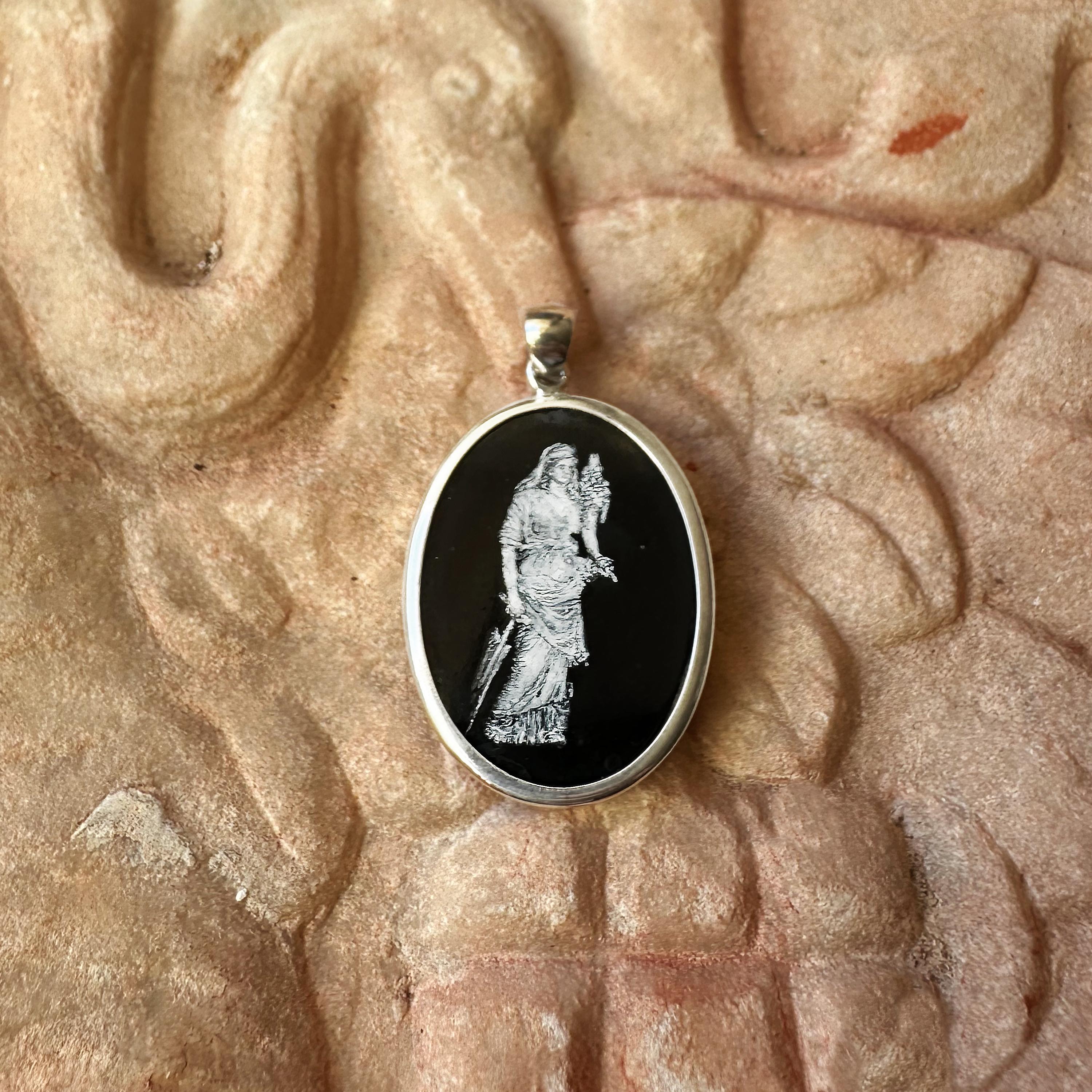 Questo ciondolo presenta una raffigurazione dipinta a mano della dea romana Fortuna, splendidamente dipinta dall'artista Tommaso Rossi su un pezzo di onice. Incastonato in una cornice d'argento 925, il disegno cattura l'essenza di Fortuna come dea