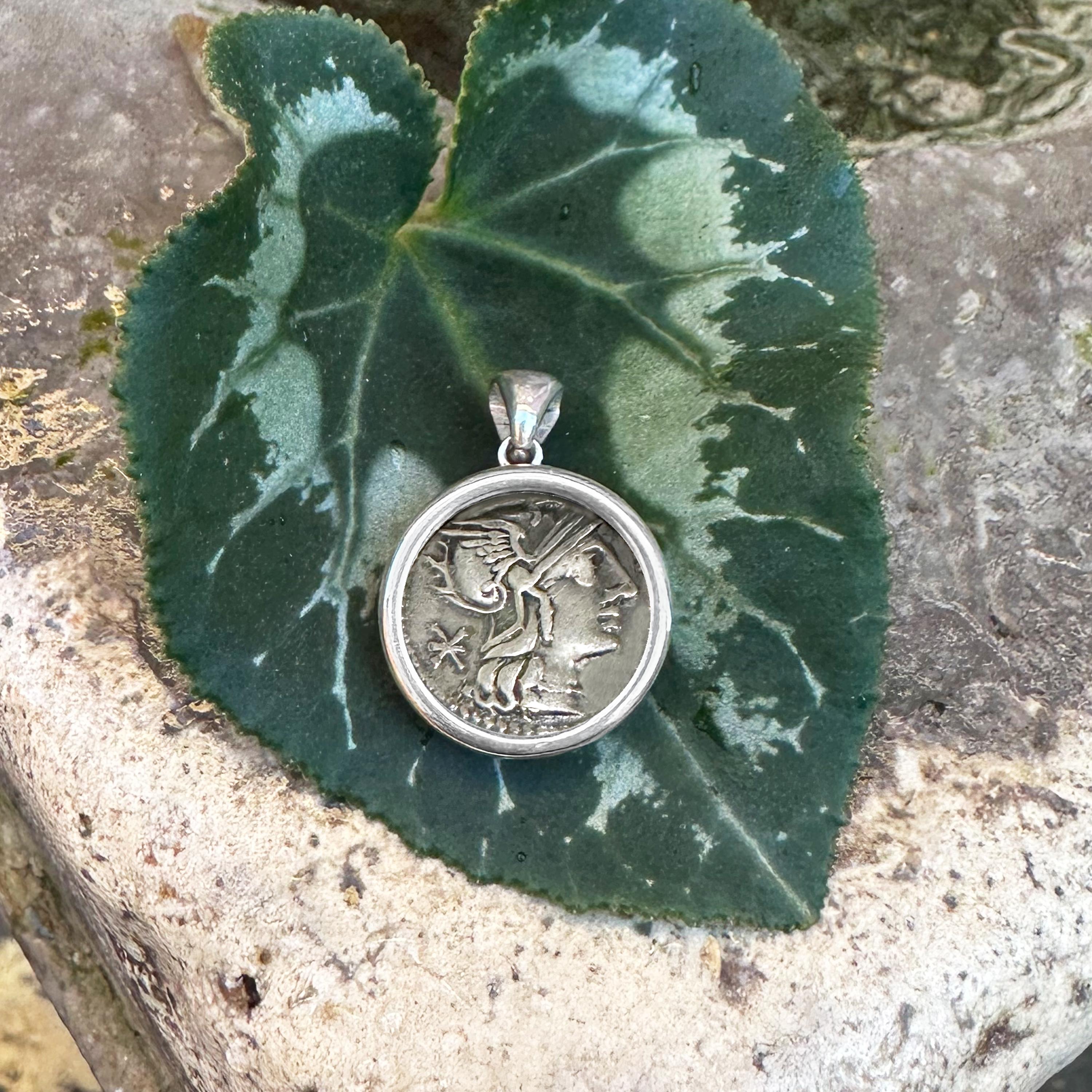 Ce pendentif en argent sterling met en valeur une authentique pièce de monnaie romaine datant de 148 avant J.-C., frappée par Sempronius Pitius. Sur une face de la pièce, on peut observer la déesse Rome ; au verso, on trouve les Dioscures, Castor et