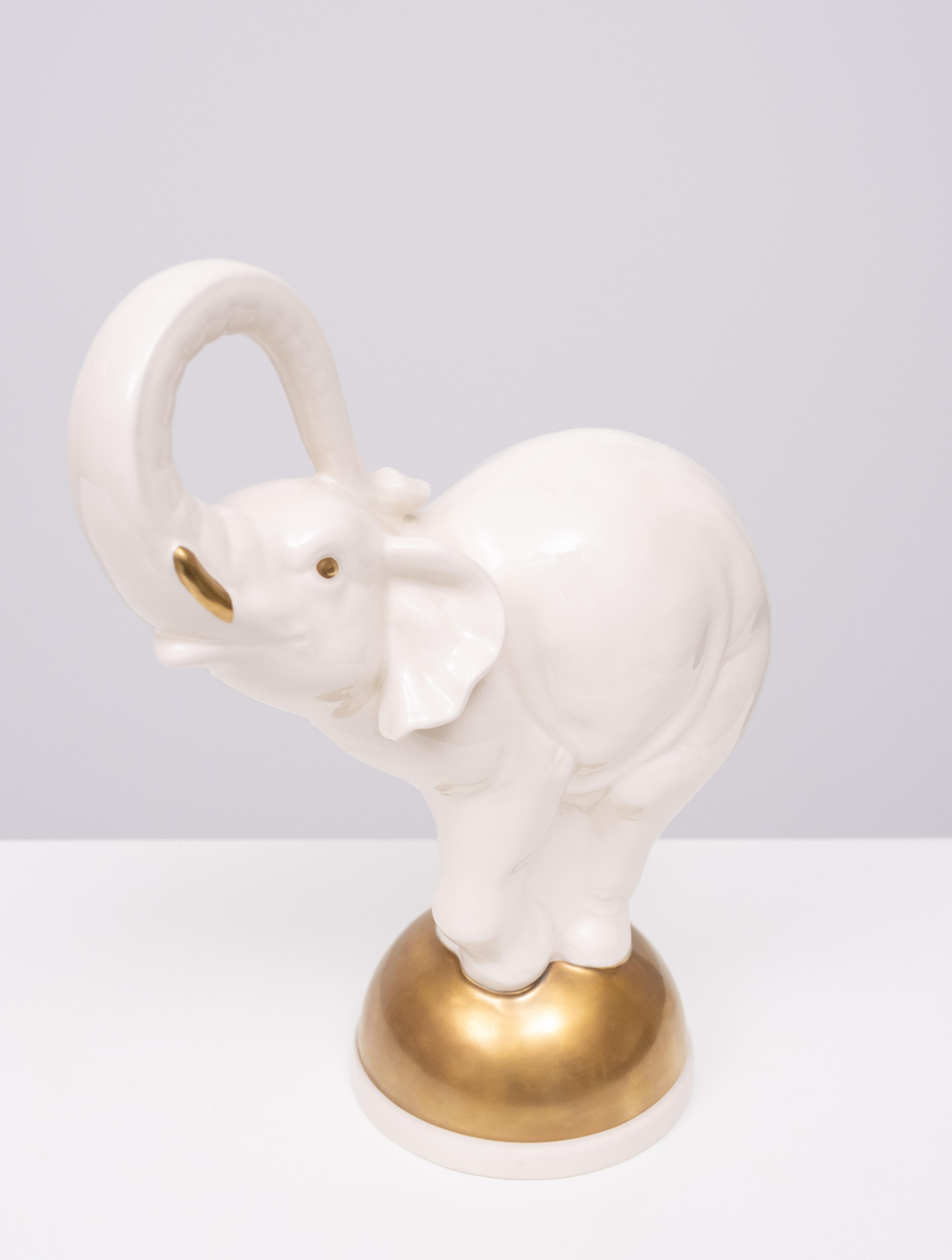 Goebel  Elefante grande de cerámica en equilibrio sobre una bola dorada  Años 70 Alemania Alemán en venta