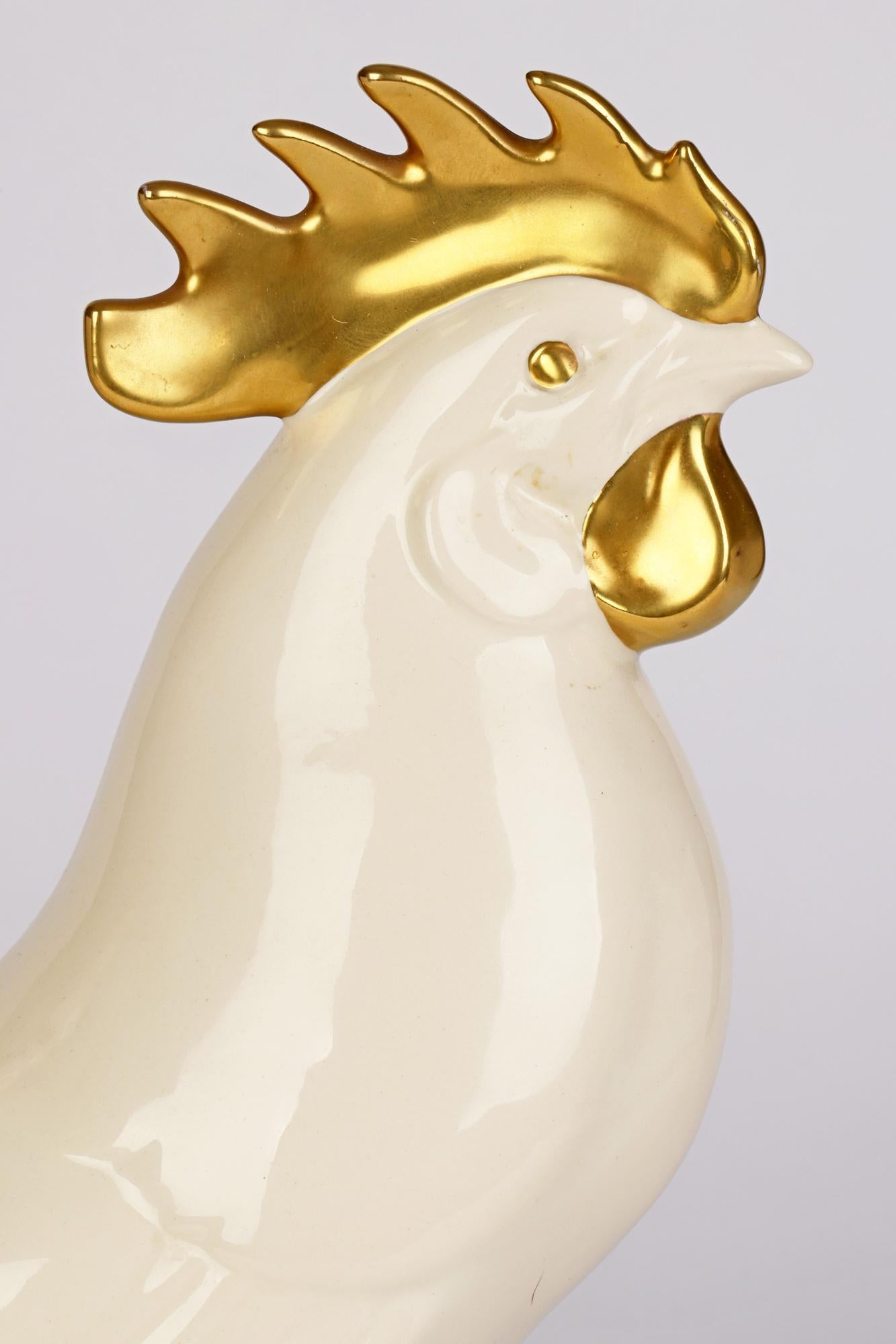 A fine German large ceramic cockerel figure dating from around 1970. The cockerel stands on a round pedestal base with incised and molded detailing with raised tail feathers and large raised comb. The cockerel is decorated in natural glazed cream