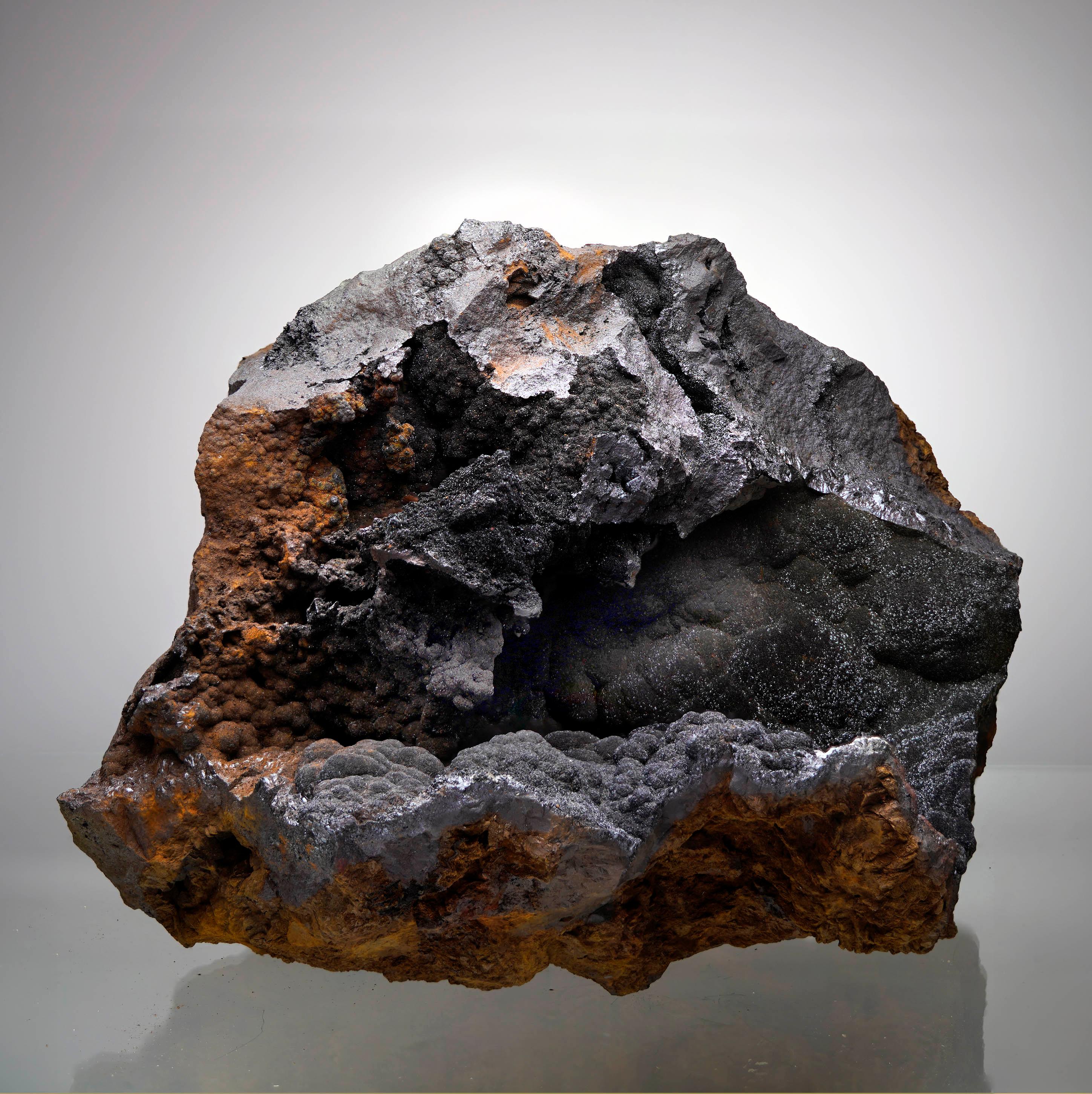 Questo straordinario vaso di Goethite proveniente dal Marocco presenta una formazione naturalmente cava rivestita da scintillanti strutture botrioidali e una ricca lucentezza metallica. I toni del marrone rossastro contrastano meravigliosamente con