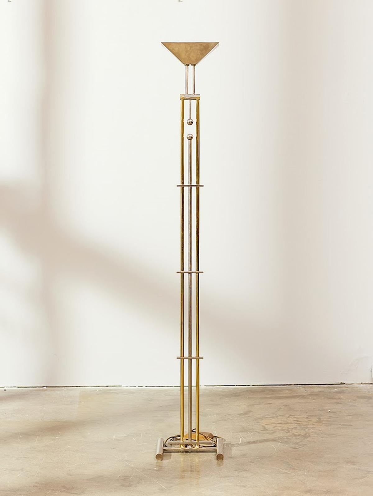 Unique floor lamp designed by Goetz, circa 1980.
Signed. Features a polished chrome adjustable shade with heavy base from chrome and brass rods.
The on/off switch is a 0-100% dimmer, located on the power cord.