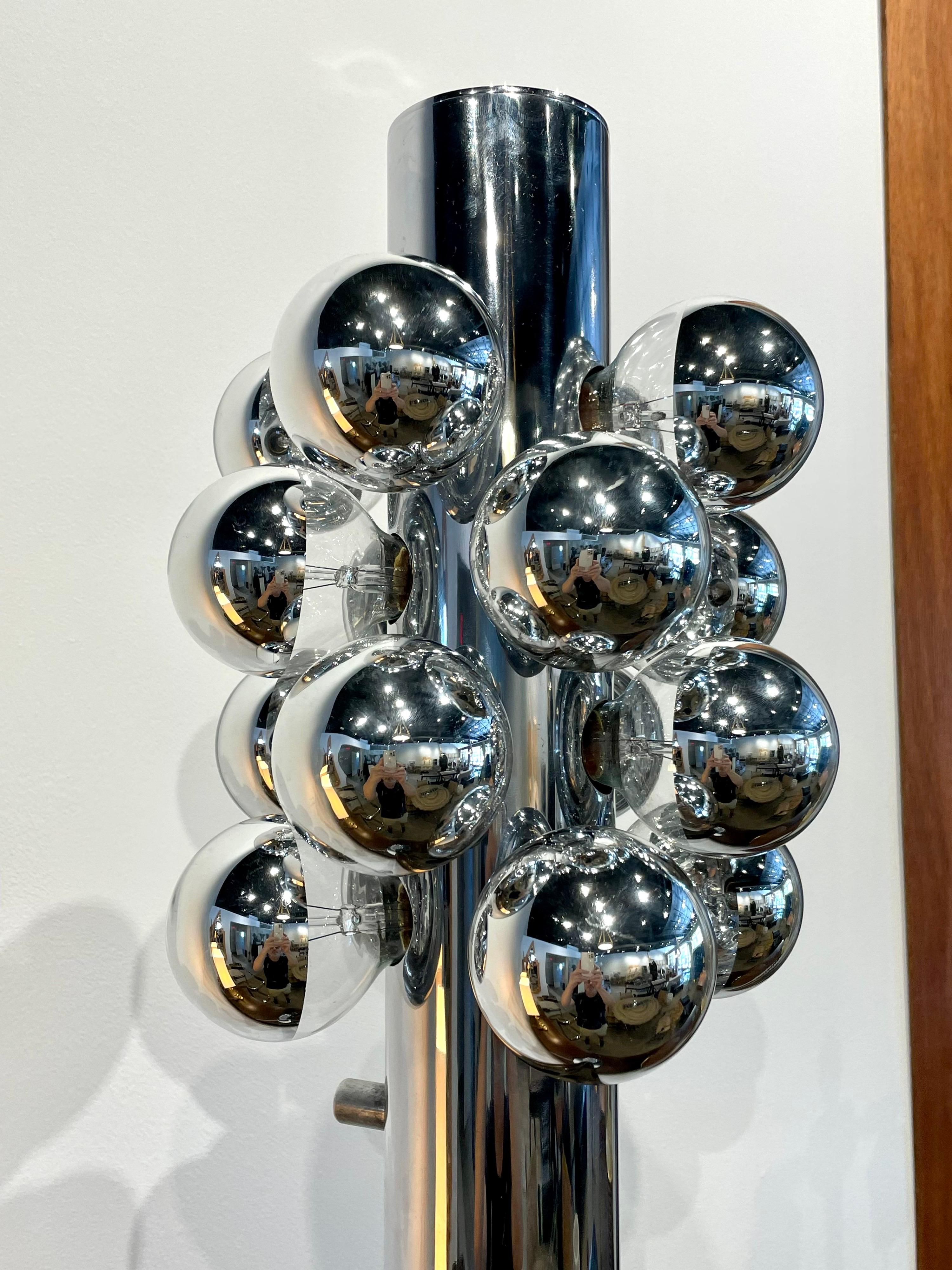 Die italienische Stehleuchte aus verchromtem Stahl ist eine originelle dekorative Lampe, die von Goffredo Reggiani in den 1970er Jahren entworfen wurde. Beleuchtet von einer Gruppe verchromter Glühbirnen, ist dies eine wunderbare, stilvolle Lampe.