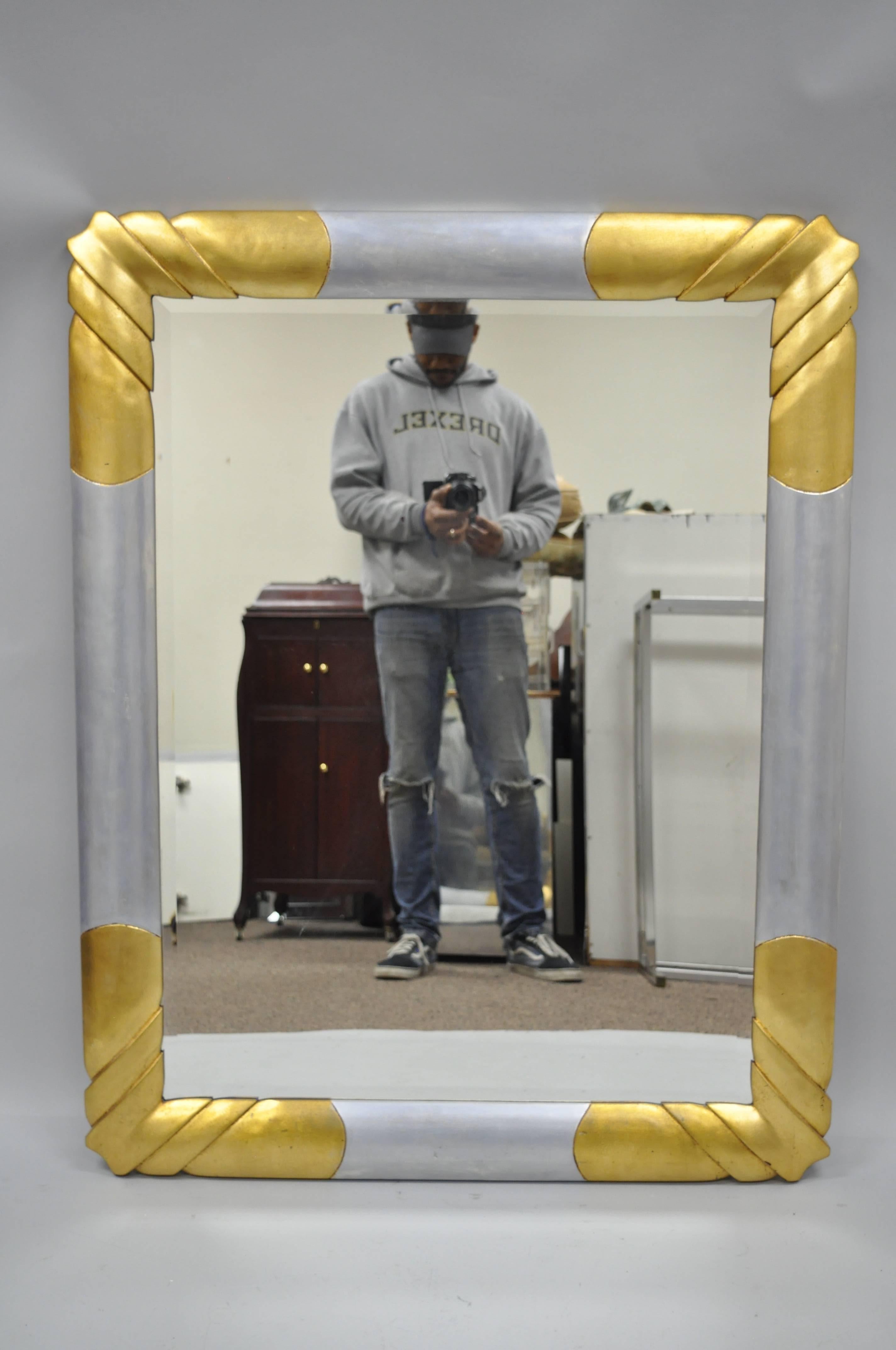 Vintage gold and silver leaf Hollywood Regency / Art Deco style wall mirror by Turner. Item features a gold and silver leaf finish, bevelled glass, molded foam frame, impressive stylish form, original label to rear. Can be hung vertical or