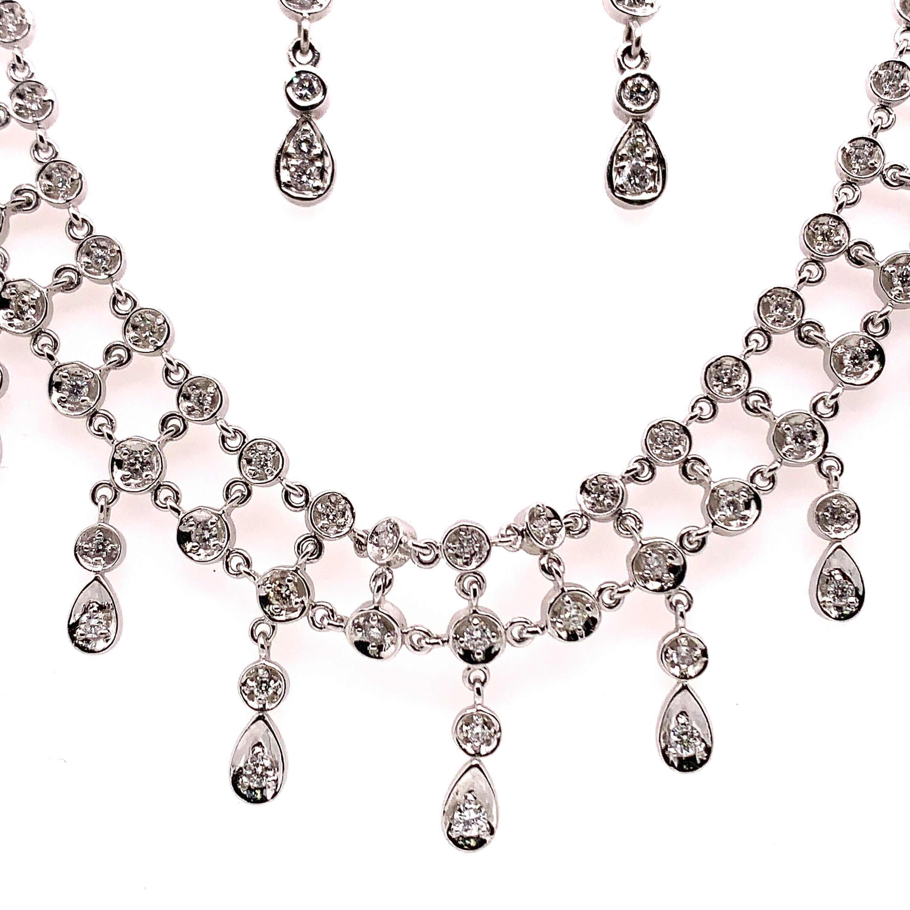 A stunning 3.10 Carat (approximately) White Gold vintage necklace set with 136 natural round brilliant diamonds approximately F-G in color and VS-SI in clarity.

The necklace includes matching diamond drop earrings.

The weight is 44.52 grams. 16