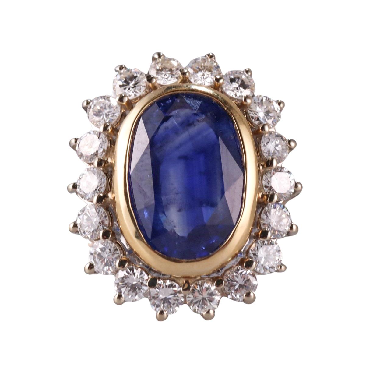 18k gold cocktail ring, with center approx. 4.70ct sapphire (stone measures 13.4 x 9.1 x 4.8mm) surrounded with approx. 1.40ctw GH/VS diamonds.  Ring size 6.5, top is 22mm x 19mm. Marked 18k. Weighs 8.9 grams.