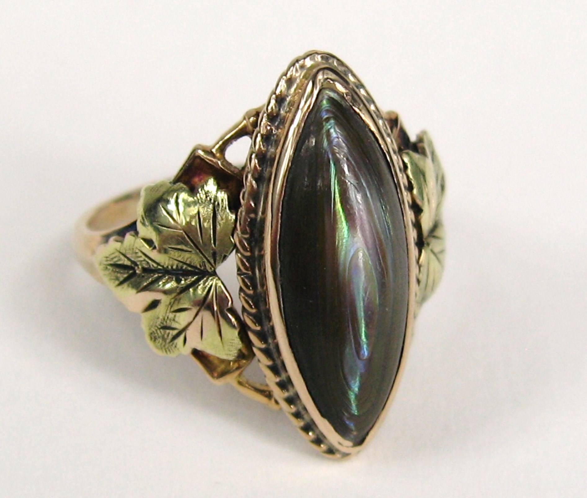 Schöner länglicher Abalone in einer 10K Tricolored Gold Fassung. Blumenmotiv auf jeder Seite des Schaftes. Ring ist eine Größe 5,5 und kann von uns oder Ihrem Juwelier angepasst werden. Schauen Sie unbedingt in unserem Geschäft nach, um weitere