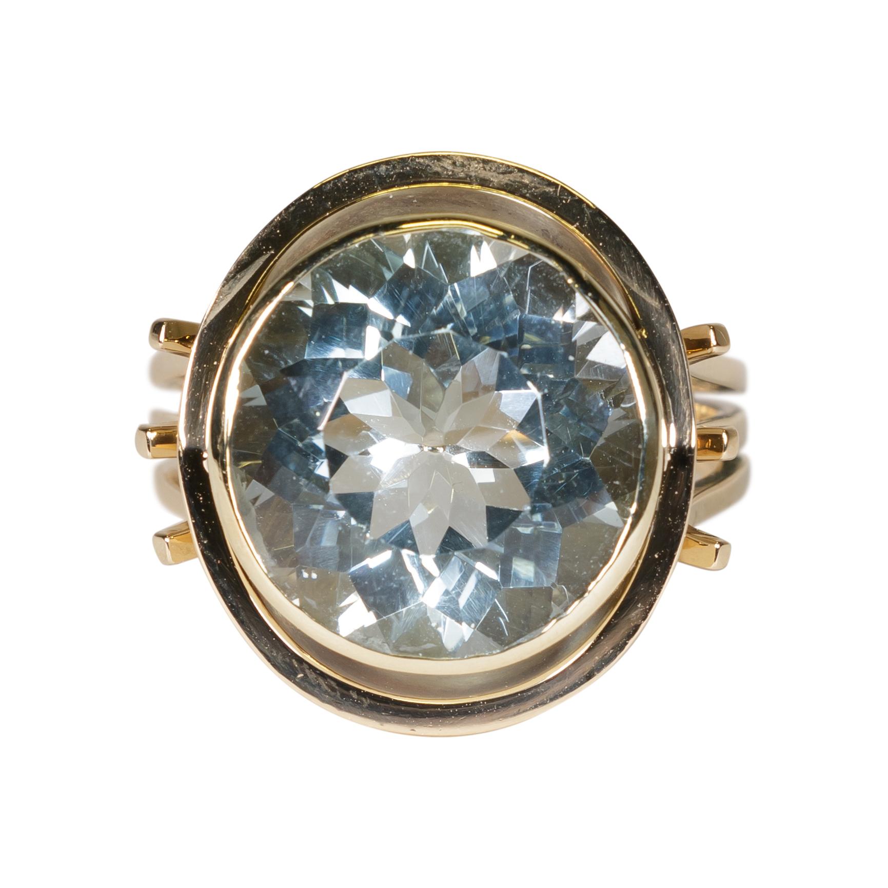 Ladies gold ring stamped 585. Center aqua stone set in a bezel around which is a gold frame with an airline style shank consisting of three rings soldered together at bottom. Mounting weight 6.48 dwt, aqua 14 x 14 x 8.5mm, weighing 9.06 carats,