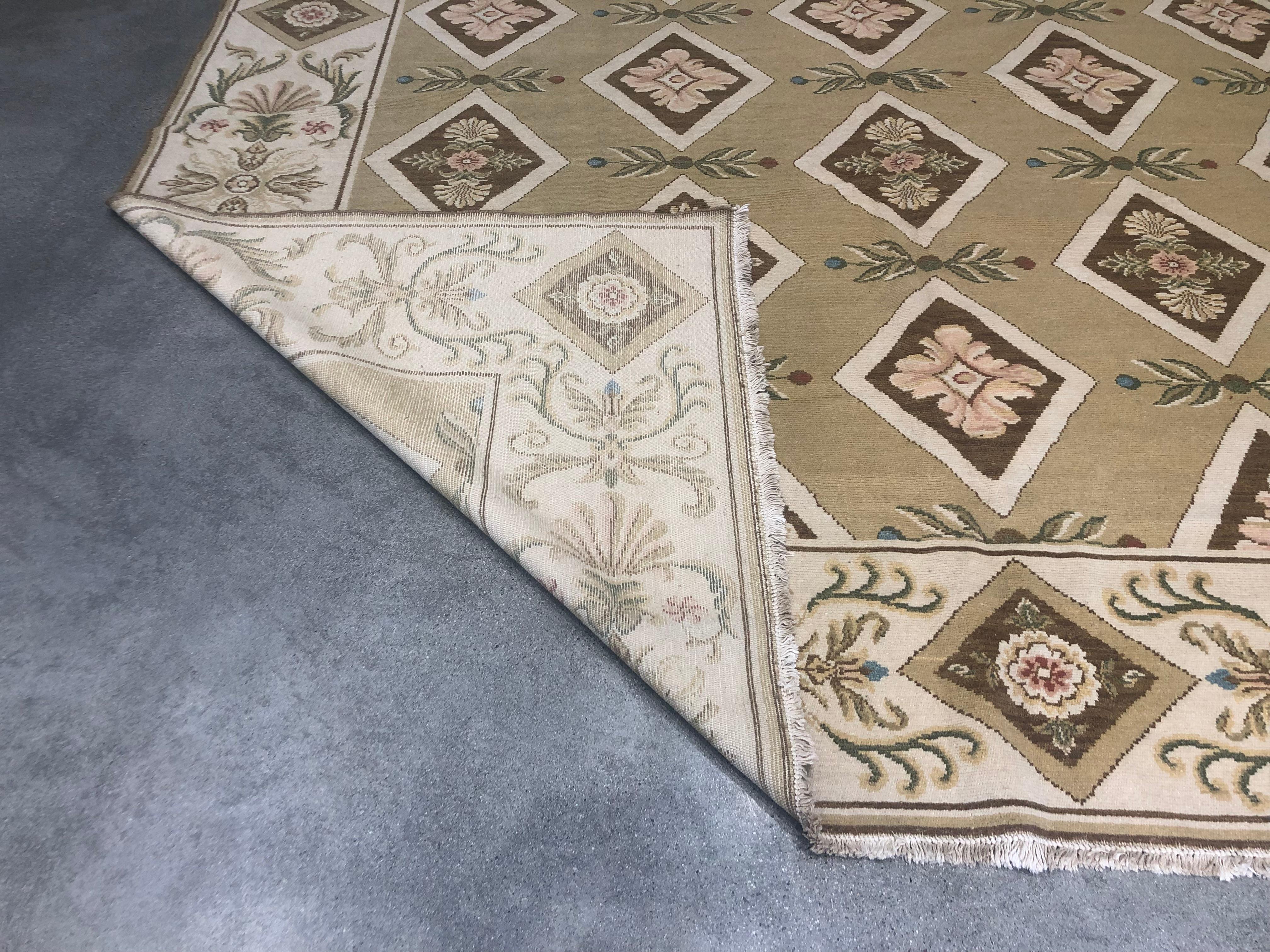 Fiori e diamanti si combinano magnificamente con un pannello centrale dorato e un bordo beige in questo tappeto di lana annodato a mano.