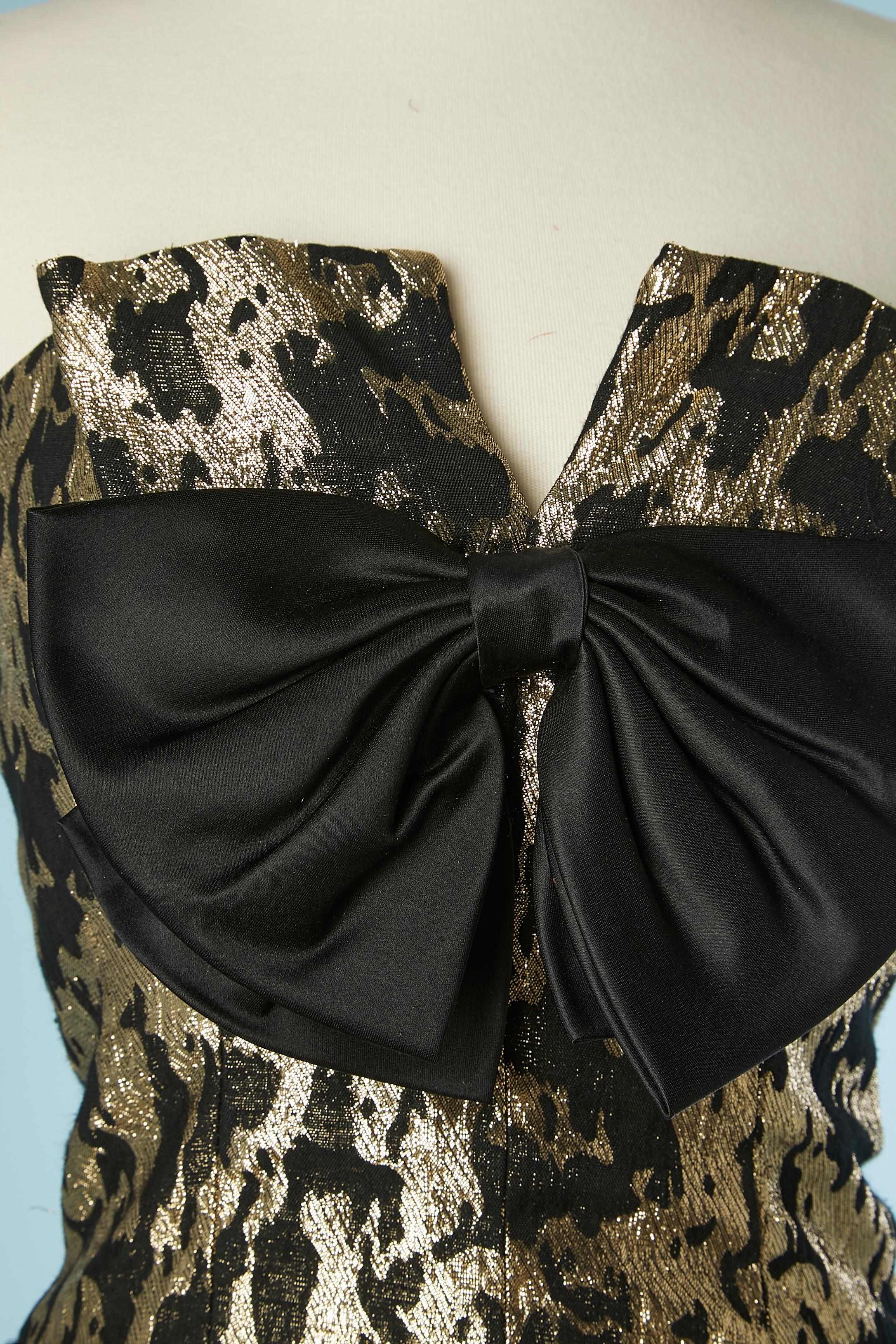  Gold and black brocade bustier cocktail dress. Black satin bow in the middle front. Boned bustier. Polyester lining and tulle petticoat with ruffles. Zip and hook&eye in the middle back. 
SIZE 4 US 