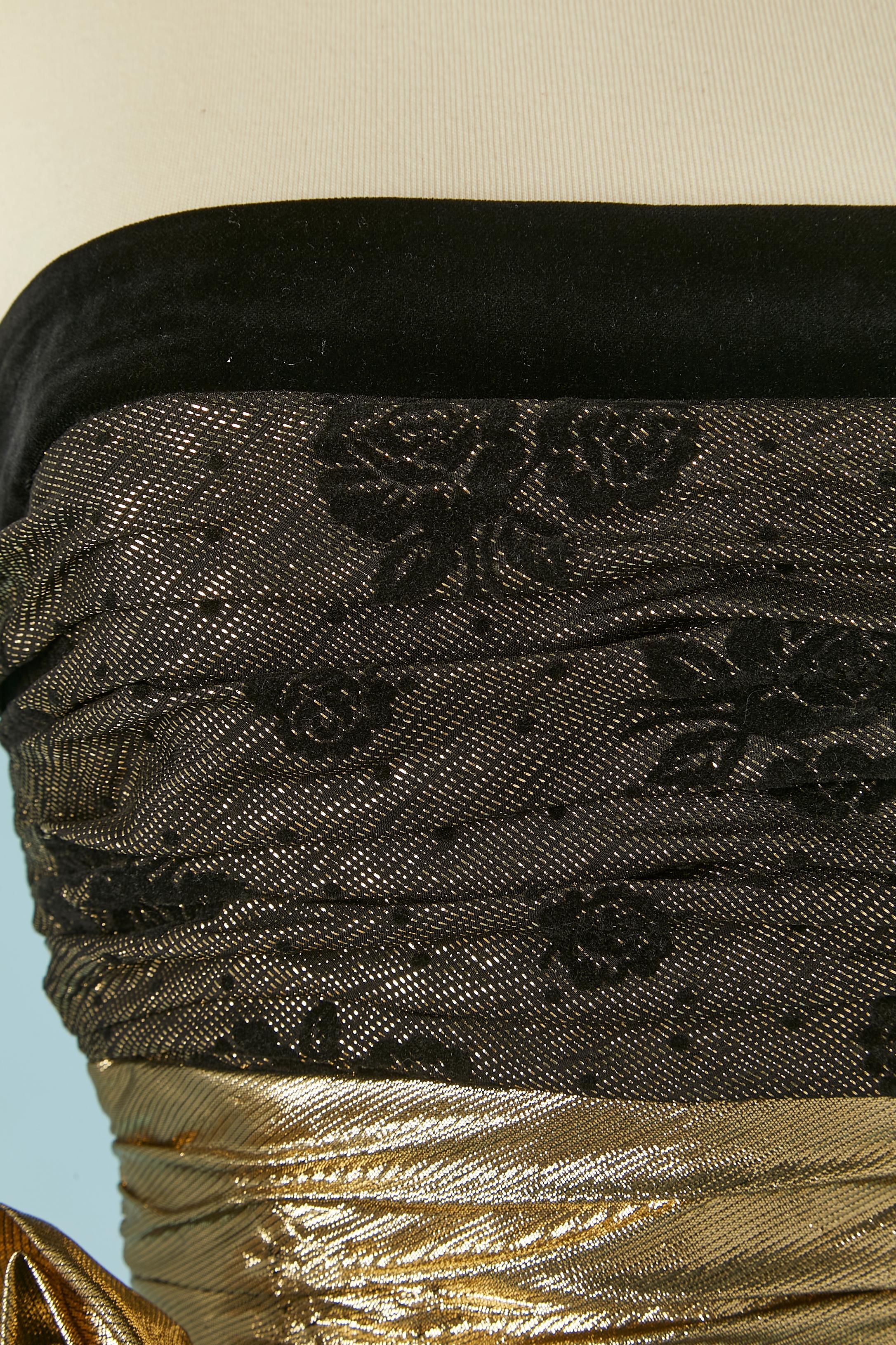 Gold and black lamé bustier evening dress. Main fabric composition: 75% rayon, 20% silk, 5% metal. Rayon lining. 
Boned bustier. Zip closure in the middle back. Waist band inside with button and buttonhole closure. Draped waist in gold lamé. Velvet