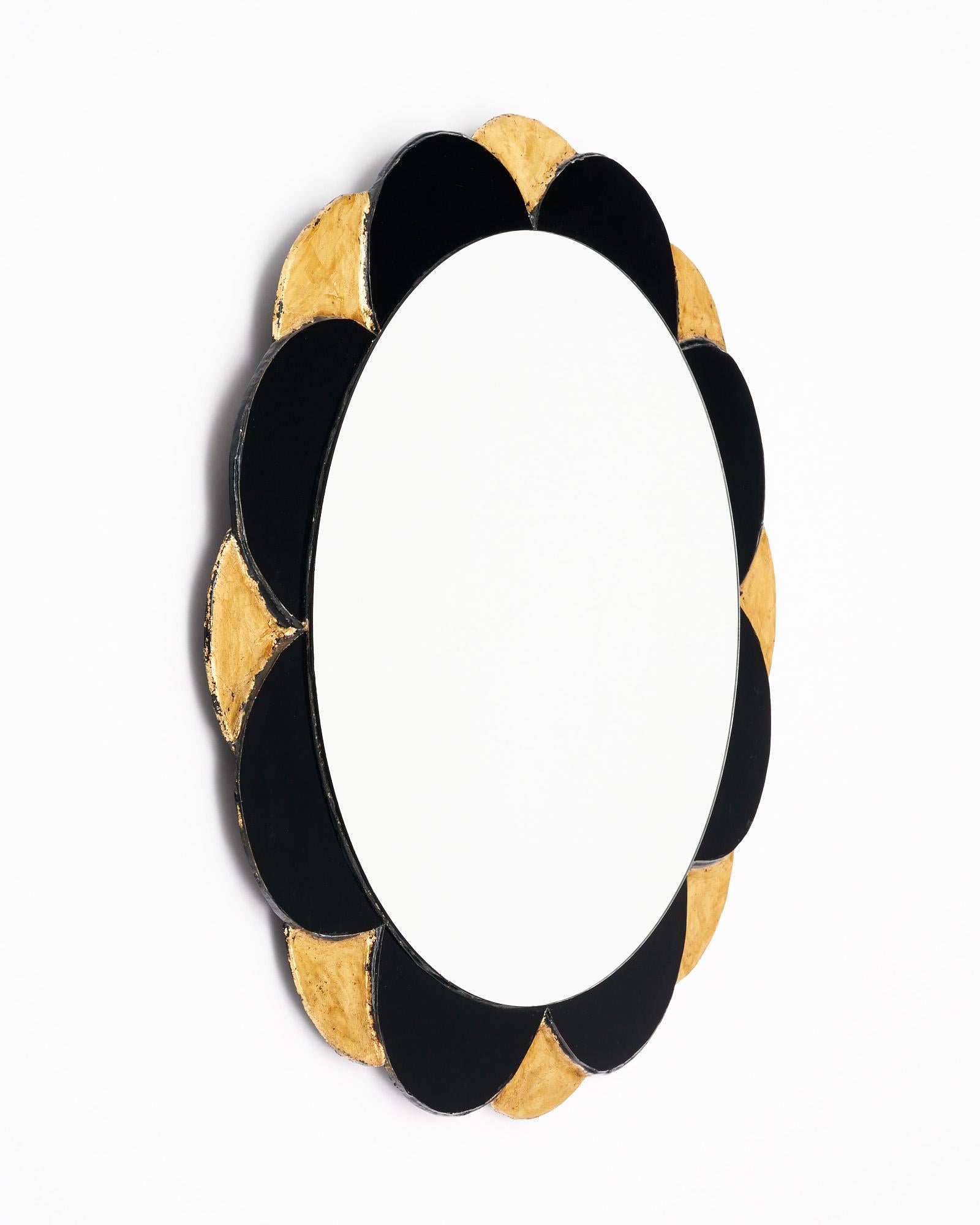 Sunburst mirror from Spain in a neo baroque style. This piece has a central circular mirror. There is a frame of black glass and gold leafed petals emanating outward. It is in very nice vintage condition with only minor surface wear consistent with
