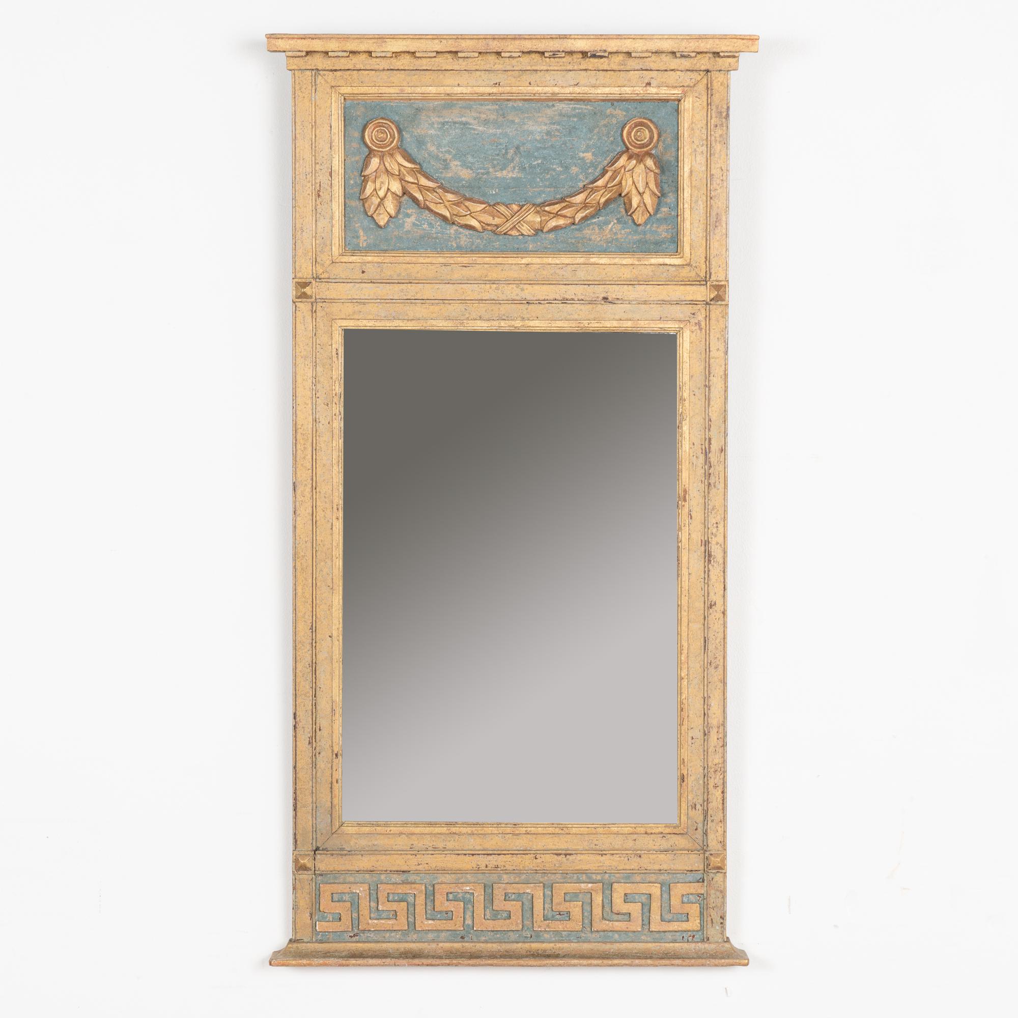 Lovely trumeau mirror with upper applied carved swag and lower Greek key pattern. At 3.5' tall, its size allows it to be displayed in a wide variety of spaces.
Restored, later professionally painted in layered shades of muted gold and blue (with