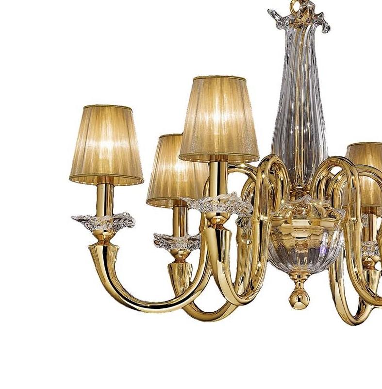 This graceful chandelier evokes a romantic atmosphere with its six elegant arms extending from a magnificent body composed of a crystal bowl and a bottle-shaped top with scalloped rim. Entirely finished with luxurious pure gold, the exquisite