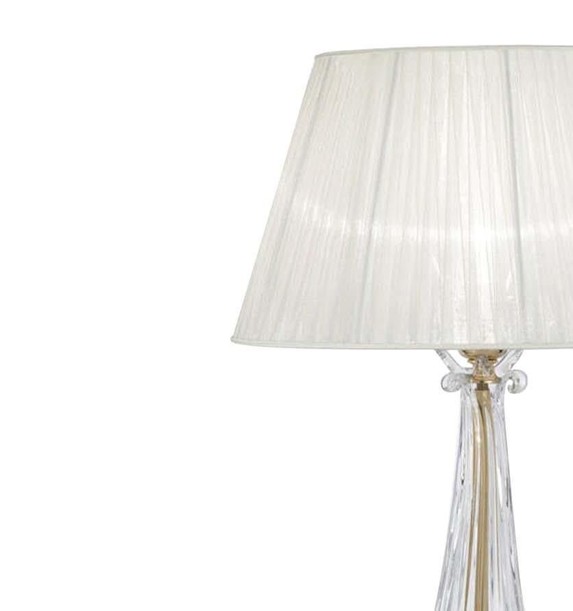 His refined lamp will provide a captivating decorative accent while casting a sophisticated ambient light in any room. The sleek body is handcrafted of clear crystal with an elongated neck and flared mouth, and raised on a gold-plated round base.