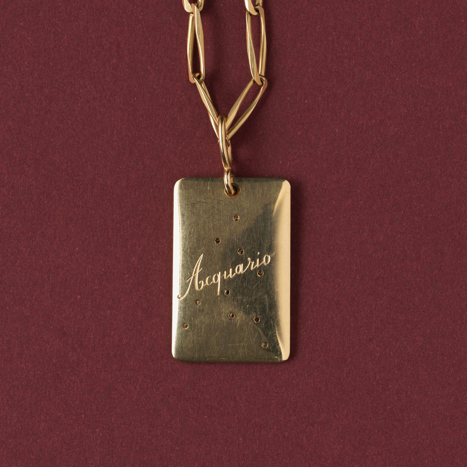 An 18 carat gold rectangular pendant with the aquarius sign set with diamonds, on the reverse engraved: Aquario, Italian maker, circa 1970.

weight: 18.11 gram
dimensions: 4.2 x 2.0 cm.